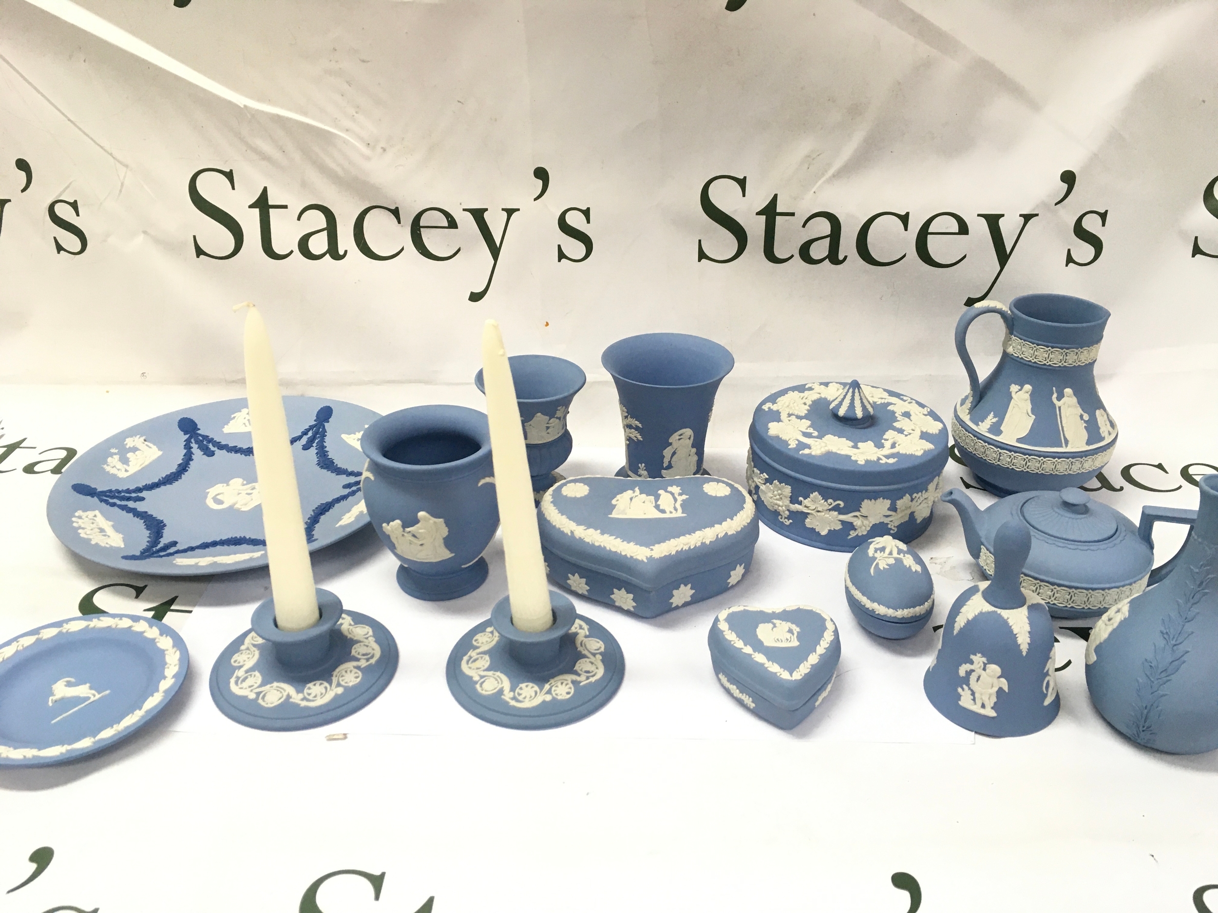 Collection of assorted wedgewood include items like a jug, teapot, and trinket boxes, along with decorative items such as a bell, candlesticks, and vases