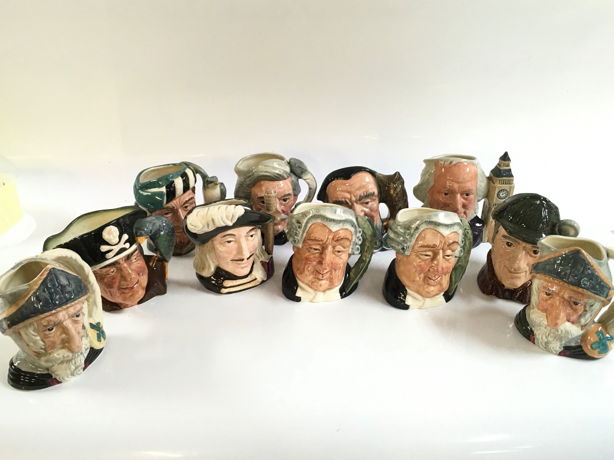 A large collection of Royal Doulton character jugs in a box, small and large mugs
