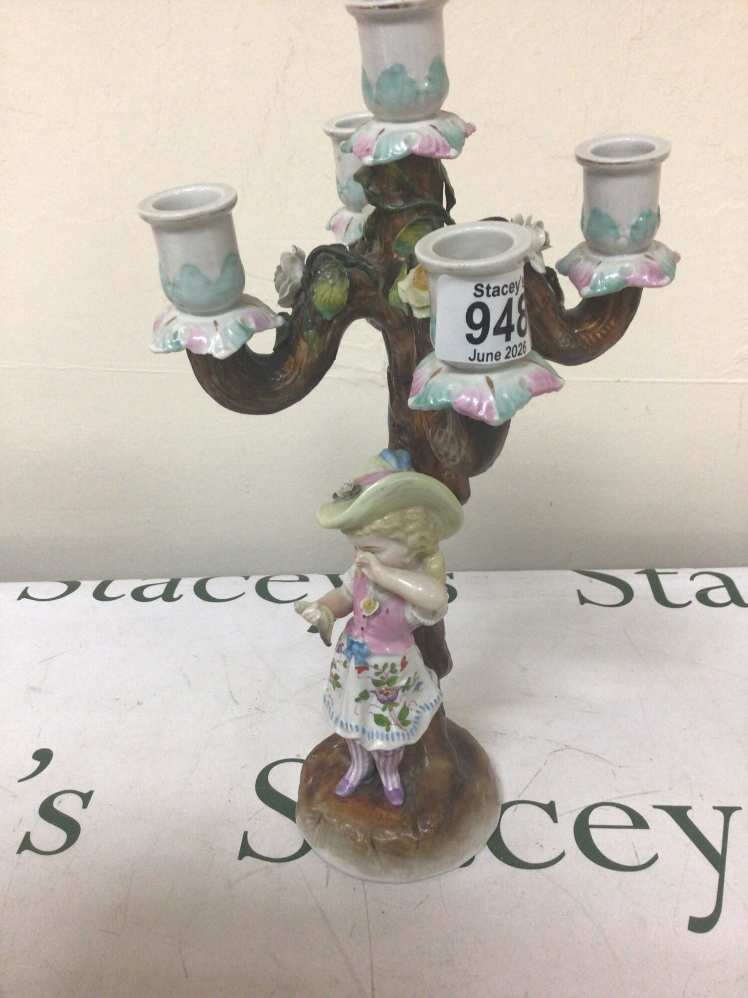A Porcelain late 19th century candelabra with a young girl standing on a naturalistic base impressed marks to the base. 35cm high. NO RESERVE
