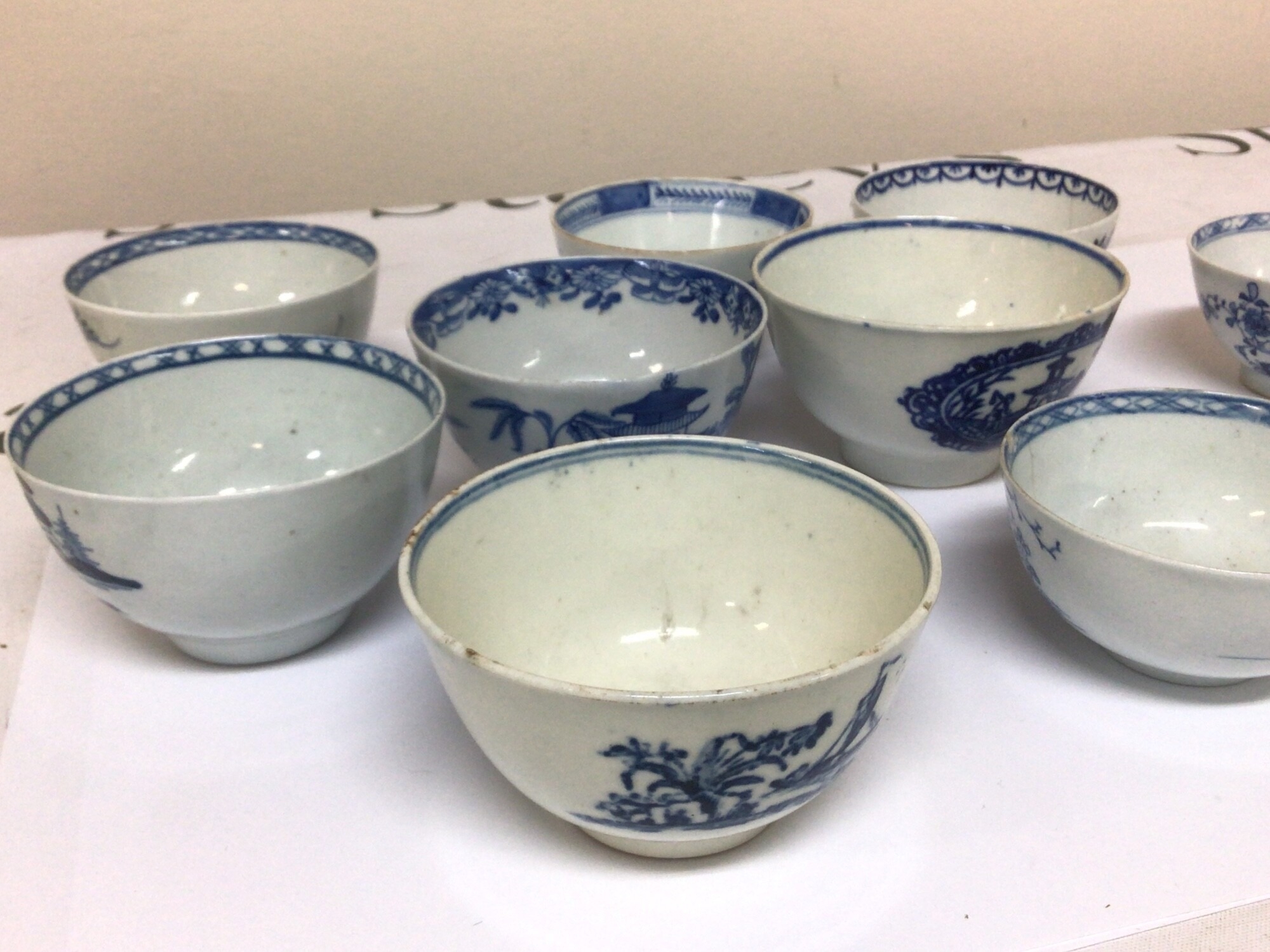 A Collection of ten English Porcelain tea bowls blue and white and decorated in the Chinese style general good condition minor rim chips and hairline cracks but not all. See images. (10)