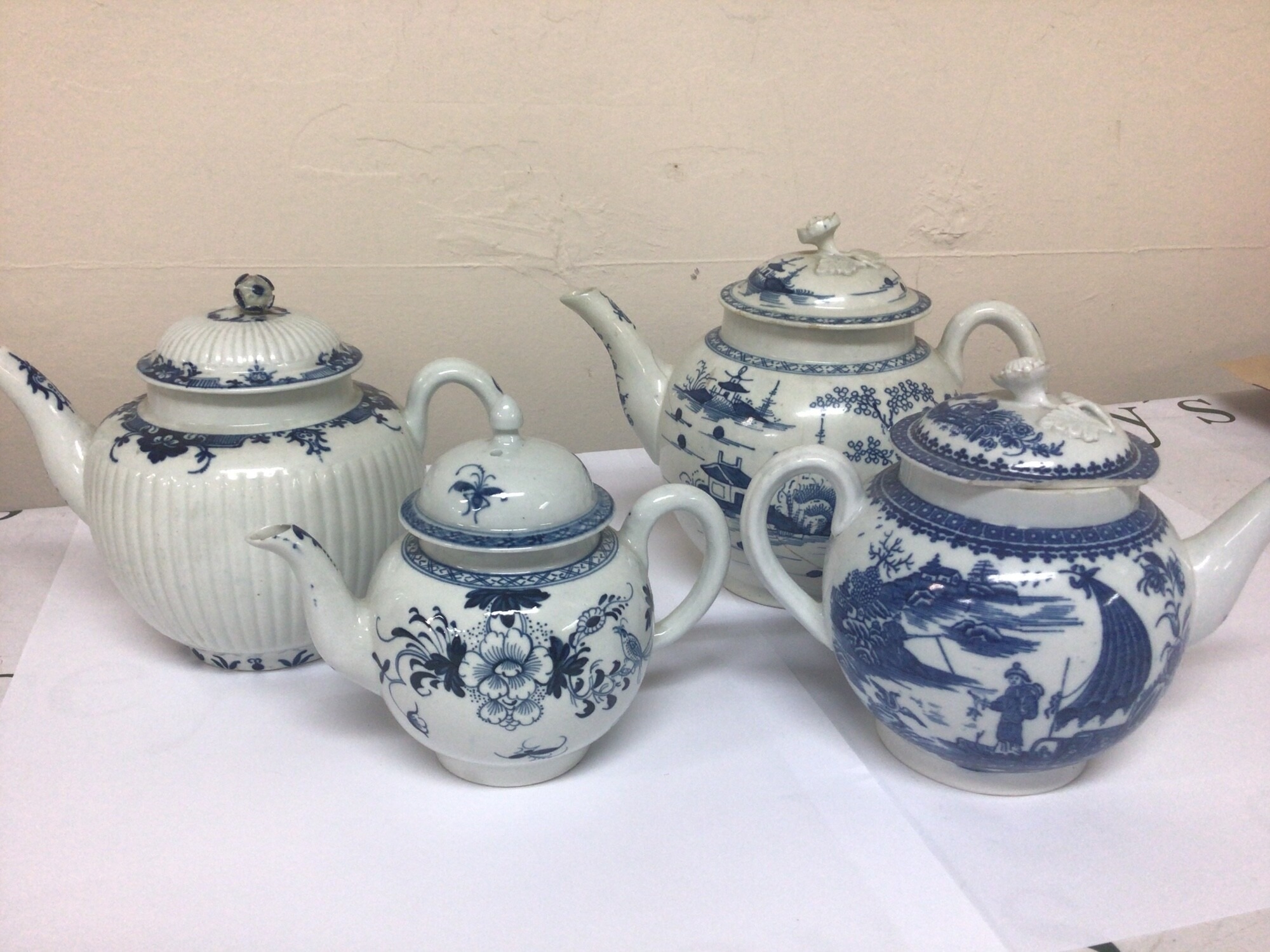 A Collection of four 18th century English porcelain tea pots decorated in the Chinese style some slight with two of the lids hairline see images the small canon shaped tea pot minor chip to the spout. (4)