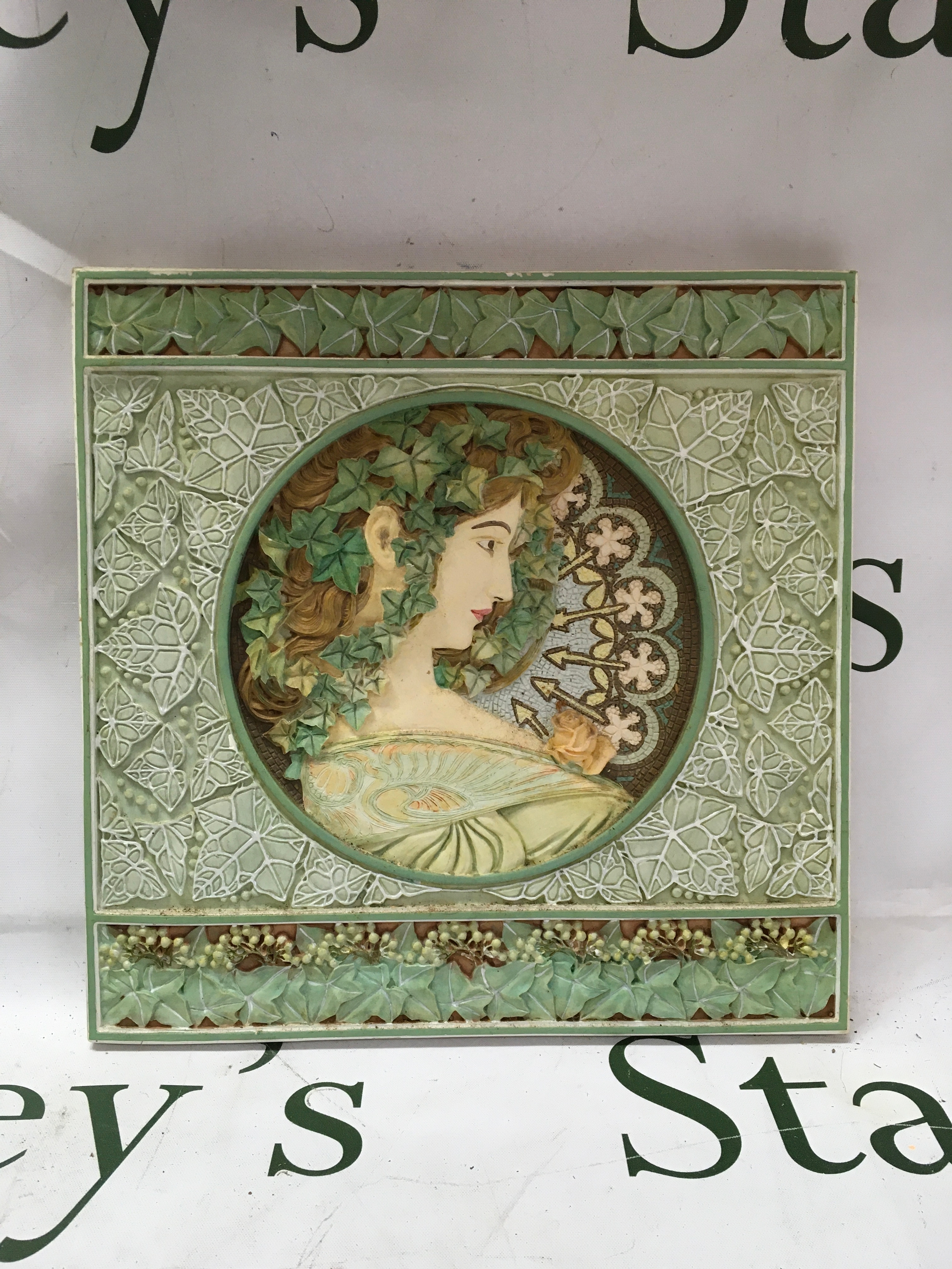 A decorative plaque featuring the Ivy design by Alphonse Mucha.