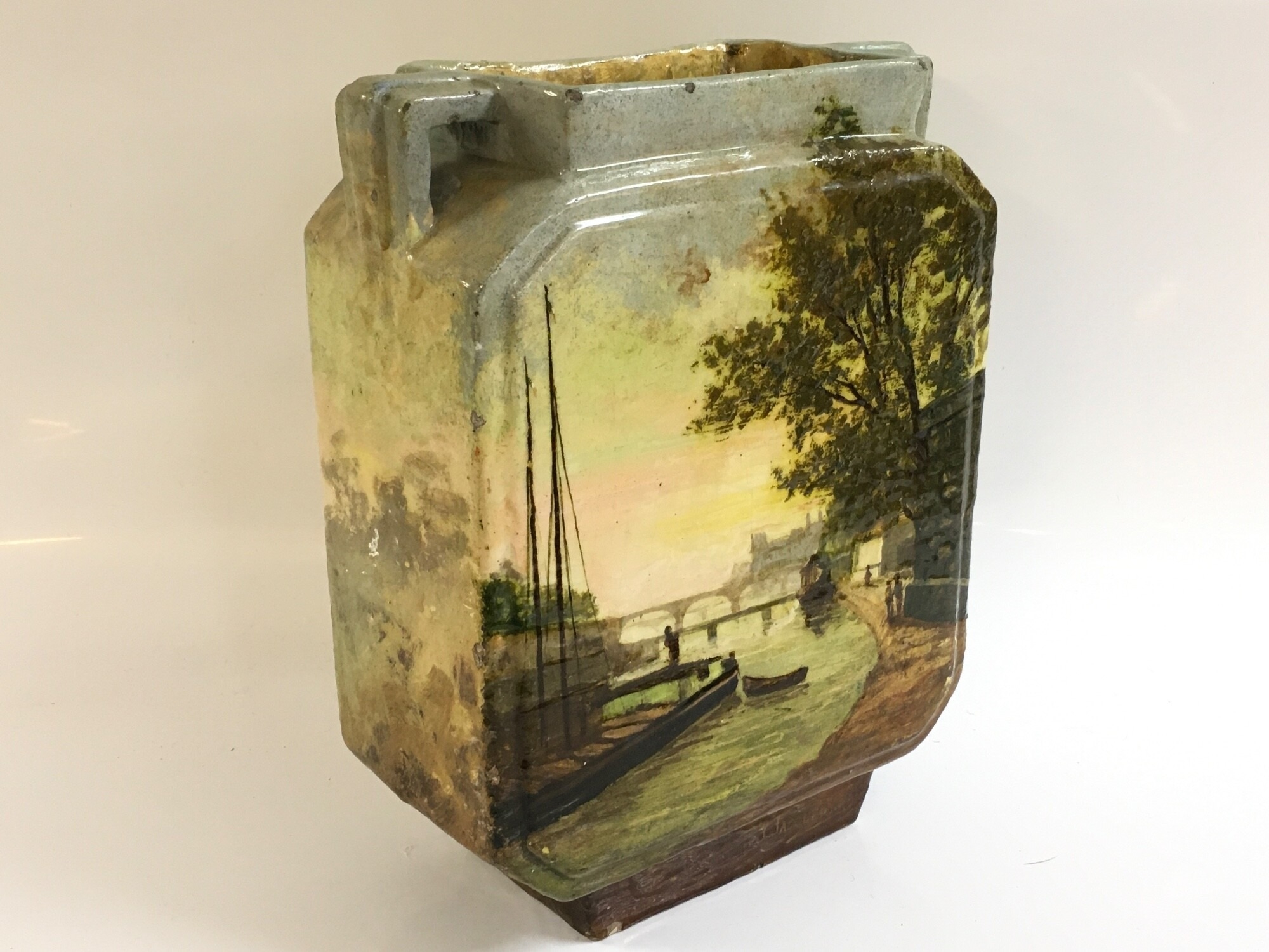 A Continental ceramic vase with a hand painted river scene signed EG for D'Edouard Gilles, 25cm tall 19cm wide.