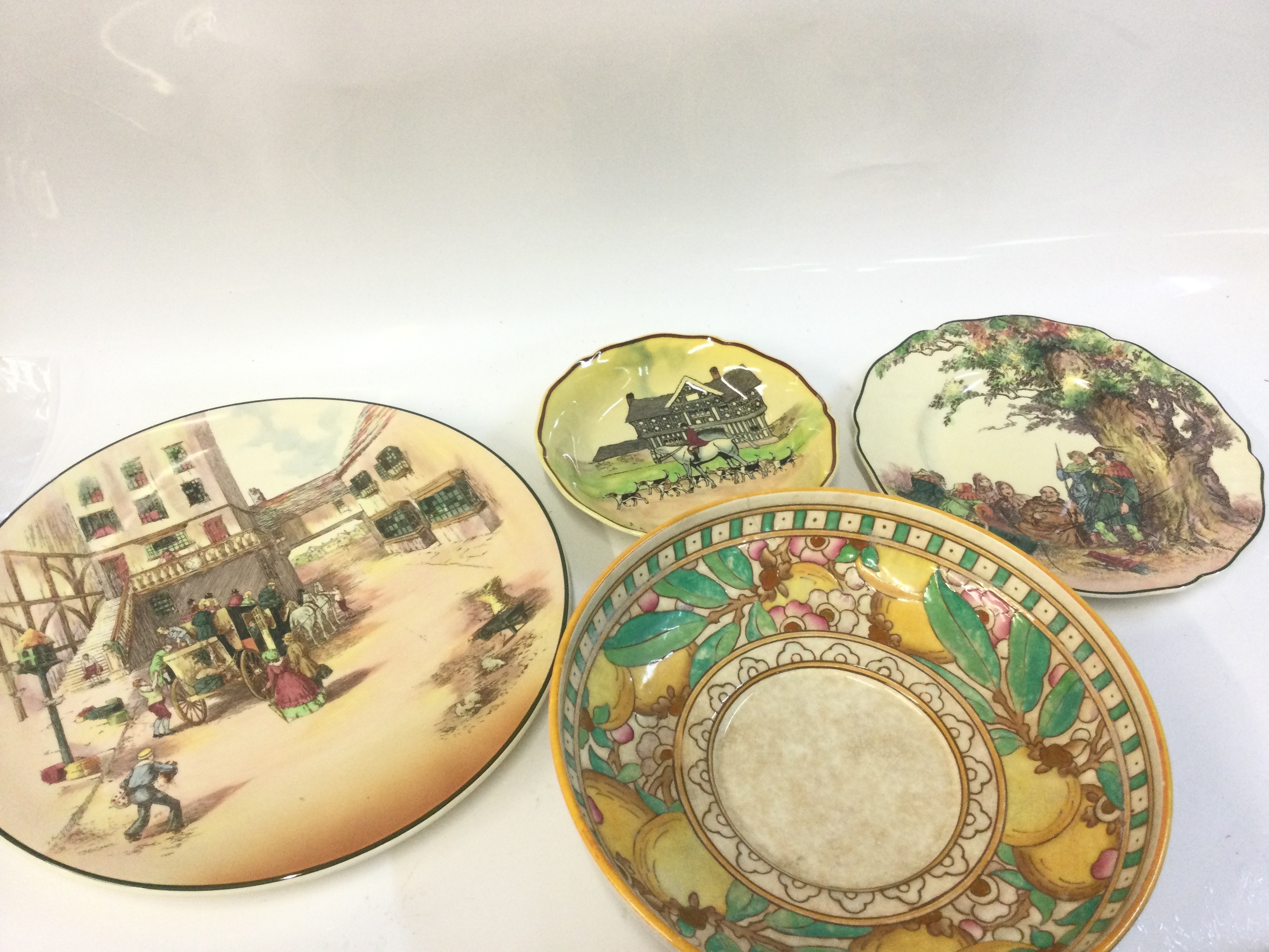 Four dishes, Three Royal Doulton including Old English Coaching scenes, The Greenwood tree (34cm wide largest) ,one Burnley Ware Charlotte Rhead dish