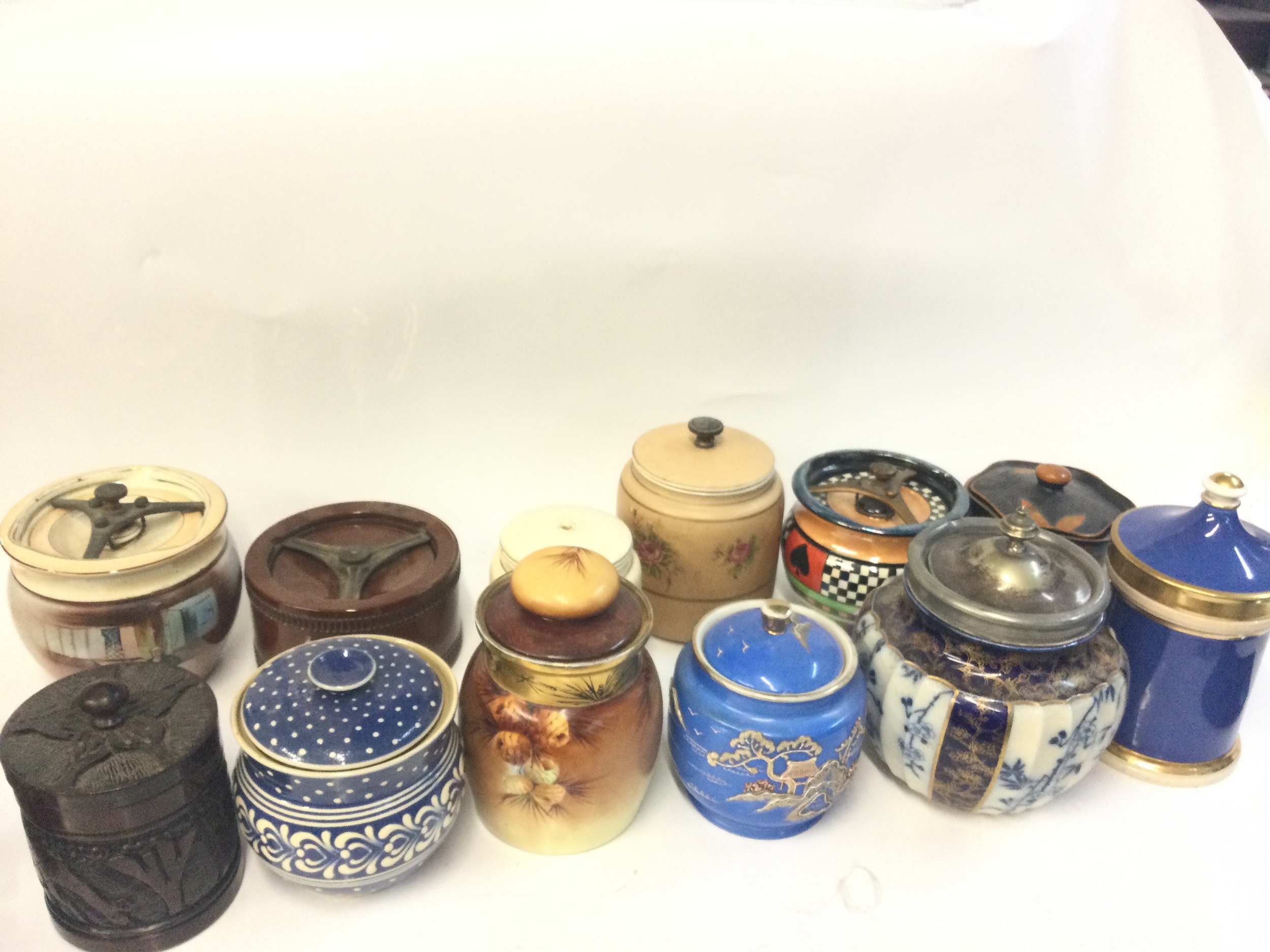 A collection of biscuit barrels and tobacco jars including ceramic and wooden examples by AFC, Favorite Bavarie, Royal Doulton & Slaters 