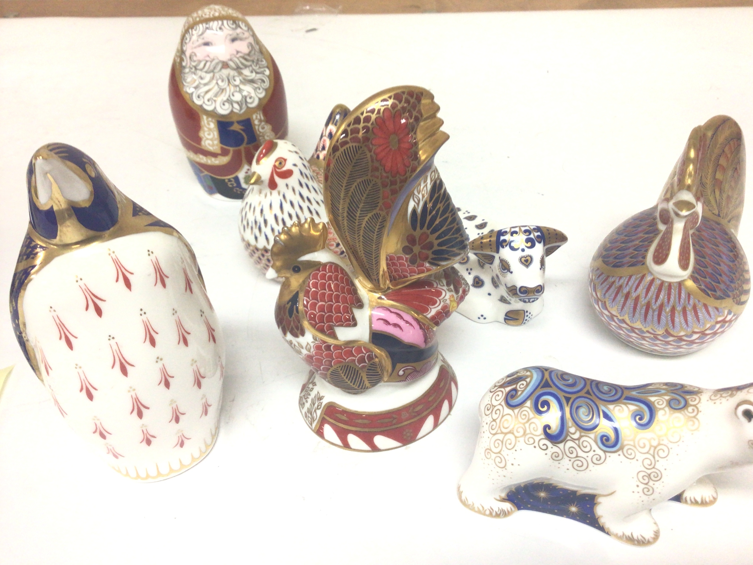 A collection of Royal Crown Derby porcelain animal and bird figures including a Fathsr Christmas figure and one Royal Worcester brightly coloured cockerel figure. No obvious damage (7) 