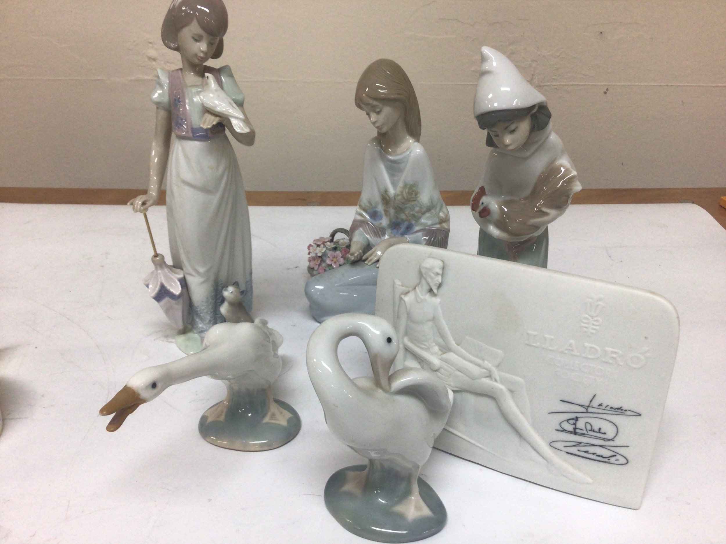  A collection of Lladro figures in the form of children with a dove a girl with a basket of flowers signed base two Ducks and a Lladro Collectors Society plaque. No obvious damage. 