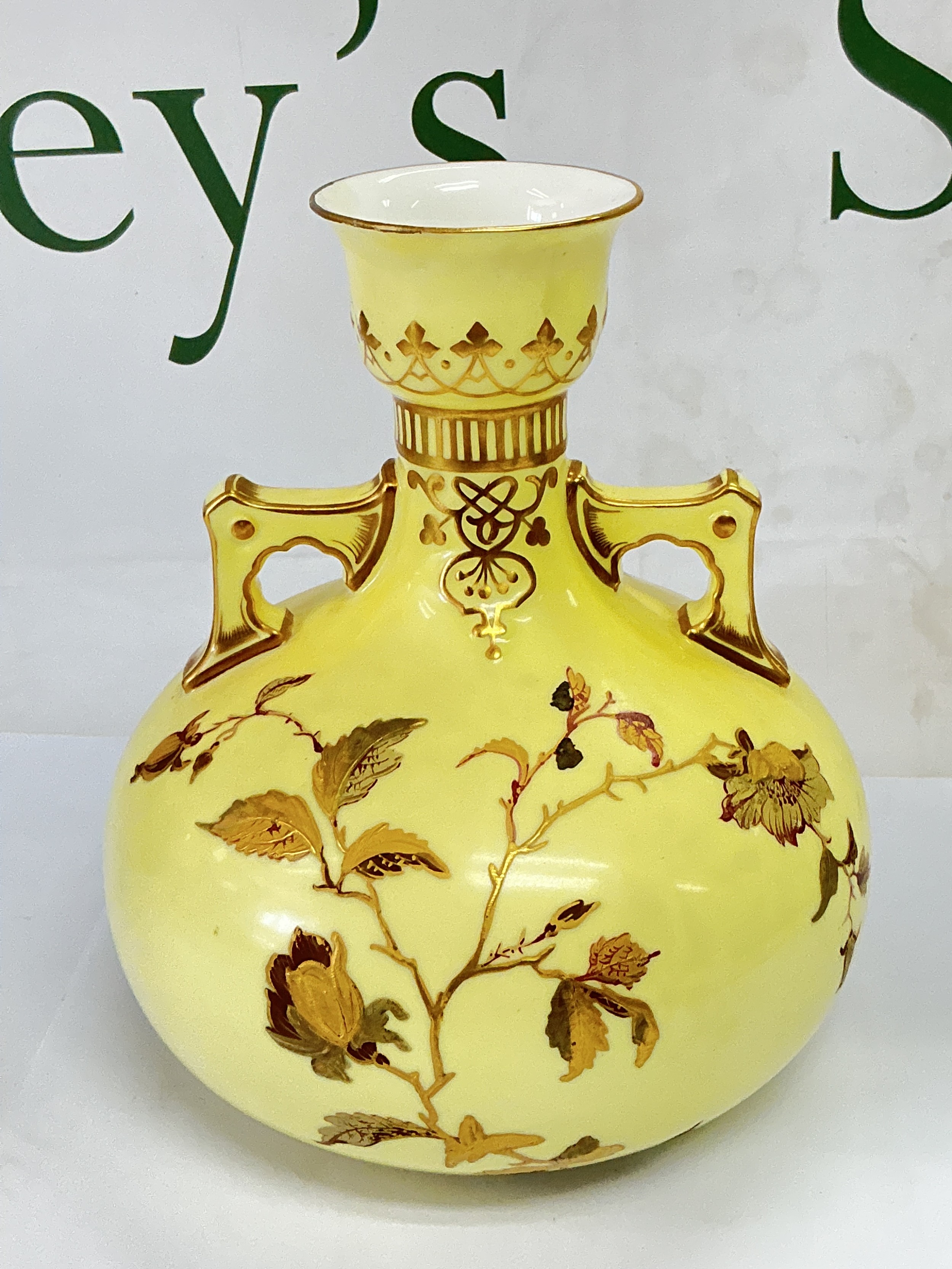 A Royal Crown Derby vase of squat form with giltwork floral decoration on a yellow ground, approx height 17cm.
