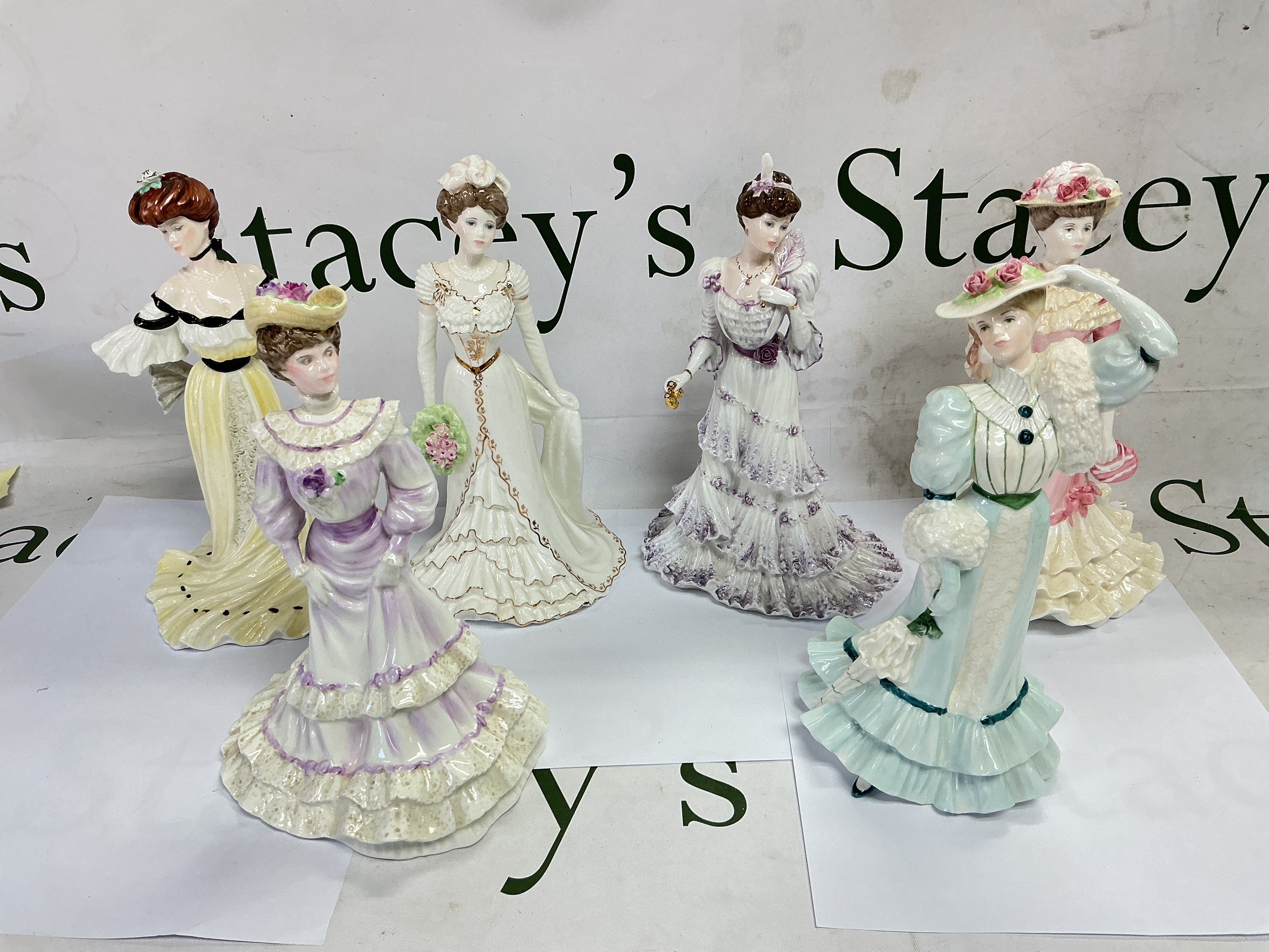 Six Coalport figures of ladies with paperwork.
