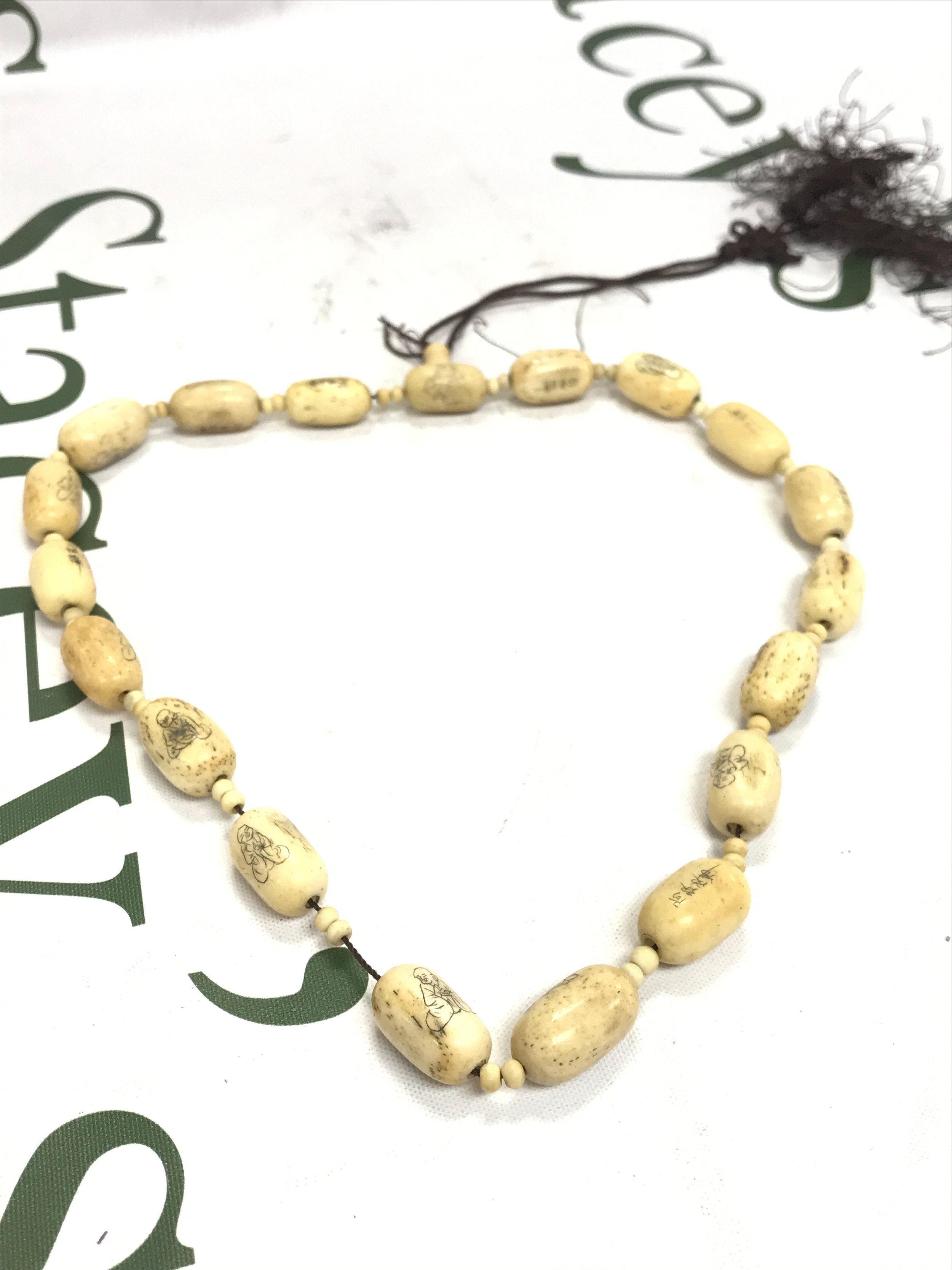Chinese prayer bead strand Buddhist mala, carved cylinderical beads engraved with small figures and text. 47cm long