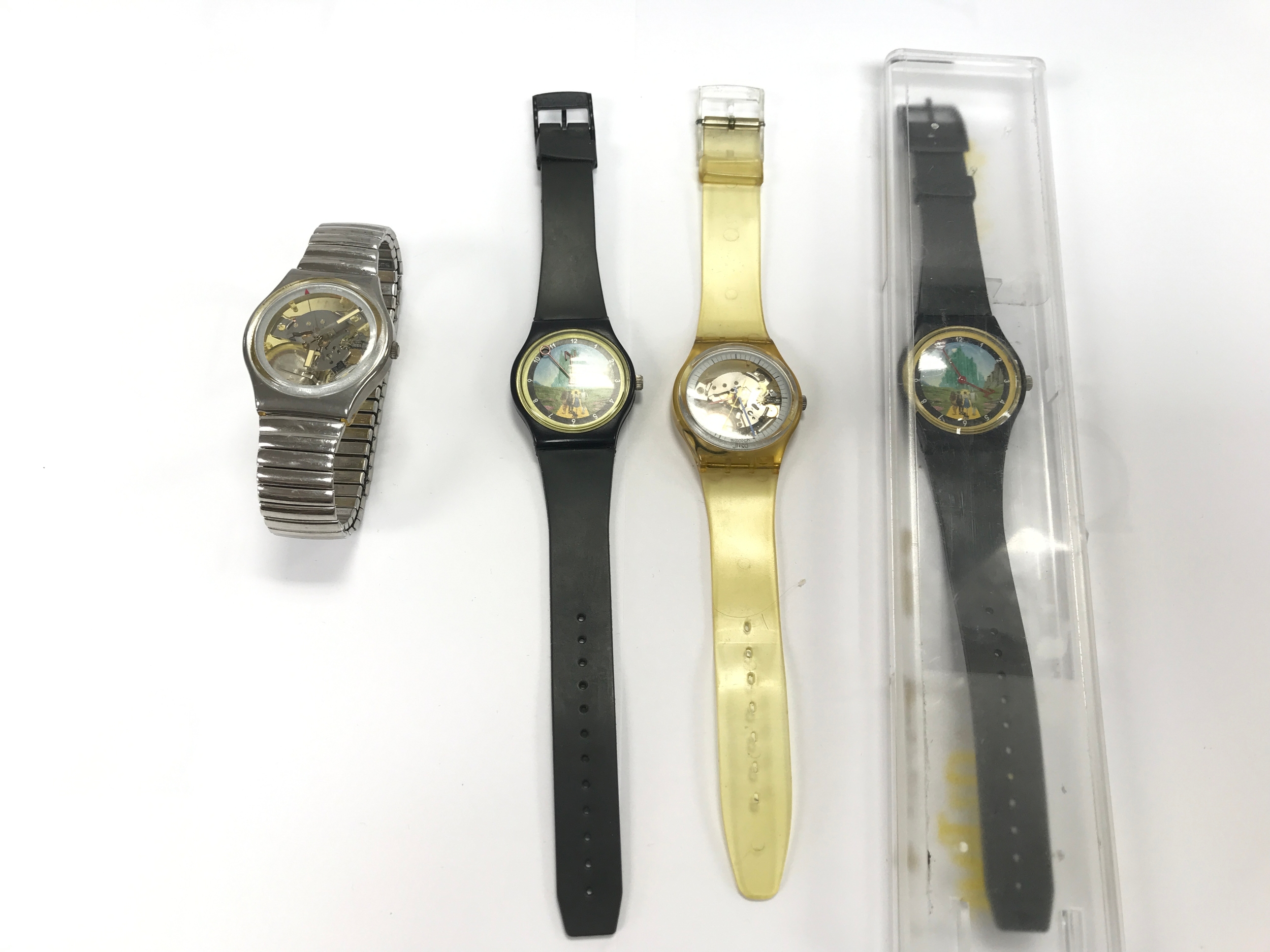 Four swatch watches including two wizard of oz examples.