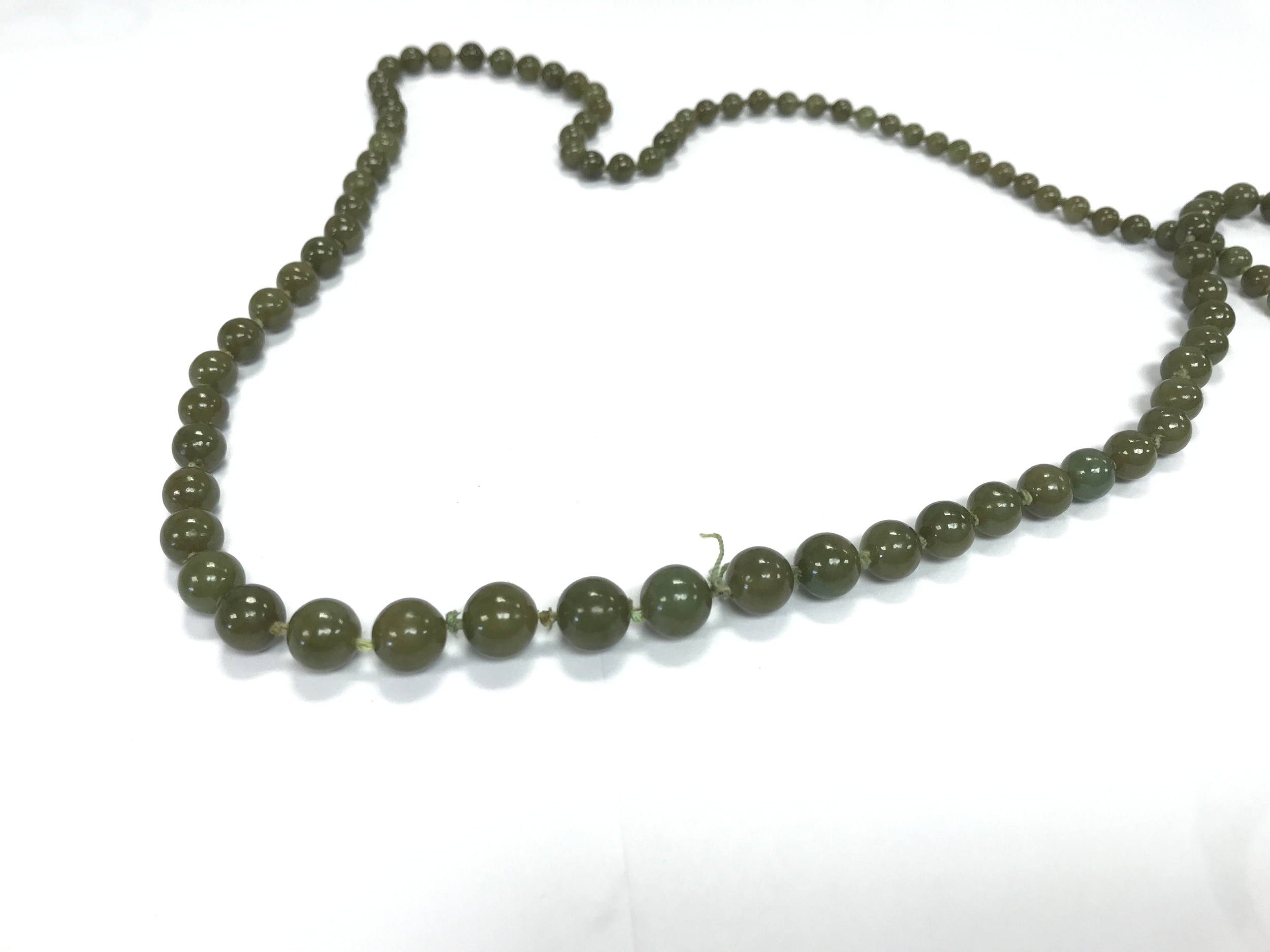 vintage green jade beaded necklace featuring graduated olive-green spheres joined by traditional hand-knotted green thread