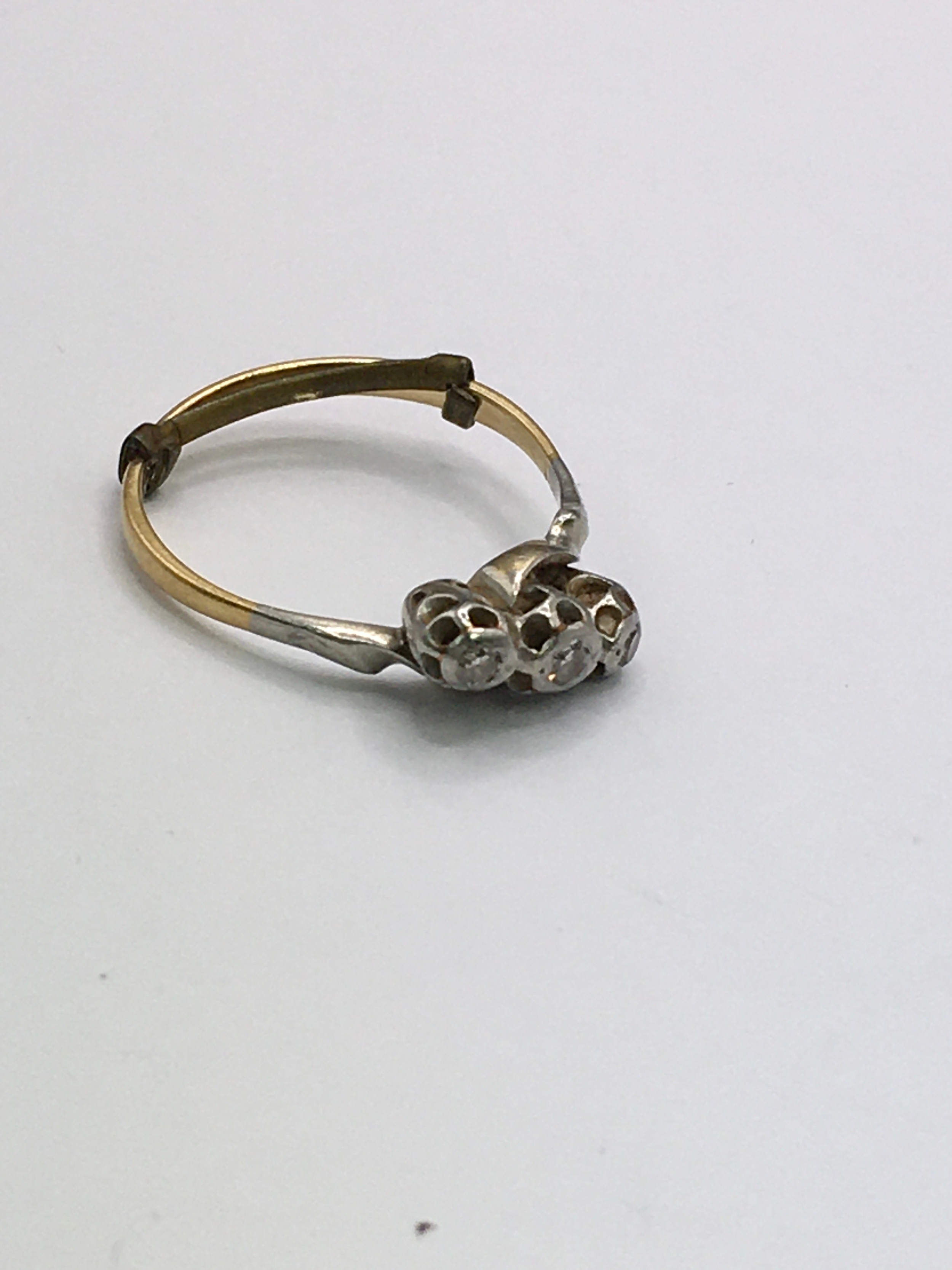 An unmarked, possible 18ct gold ring set with three old cut diamonds. Approx size P