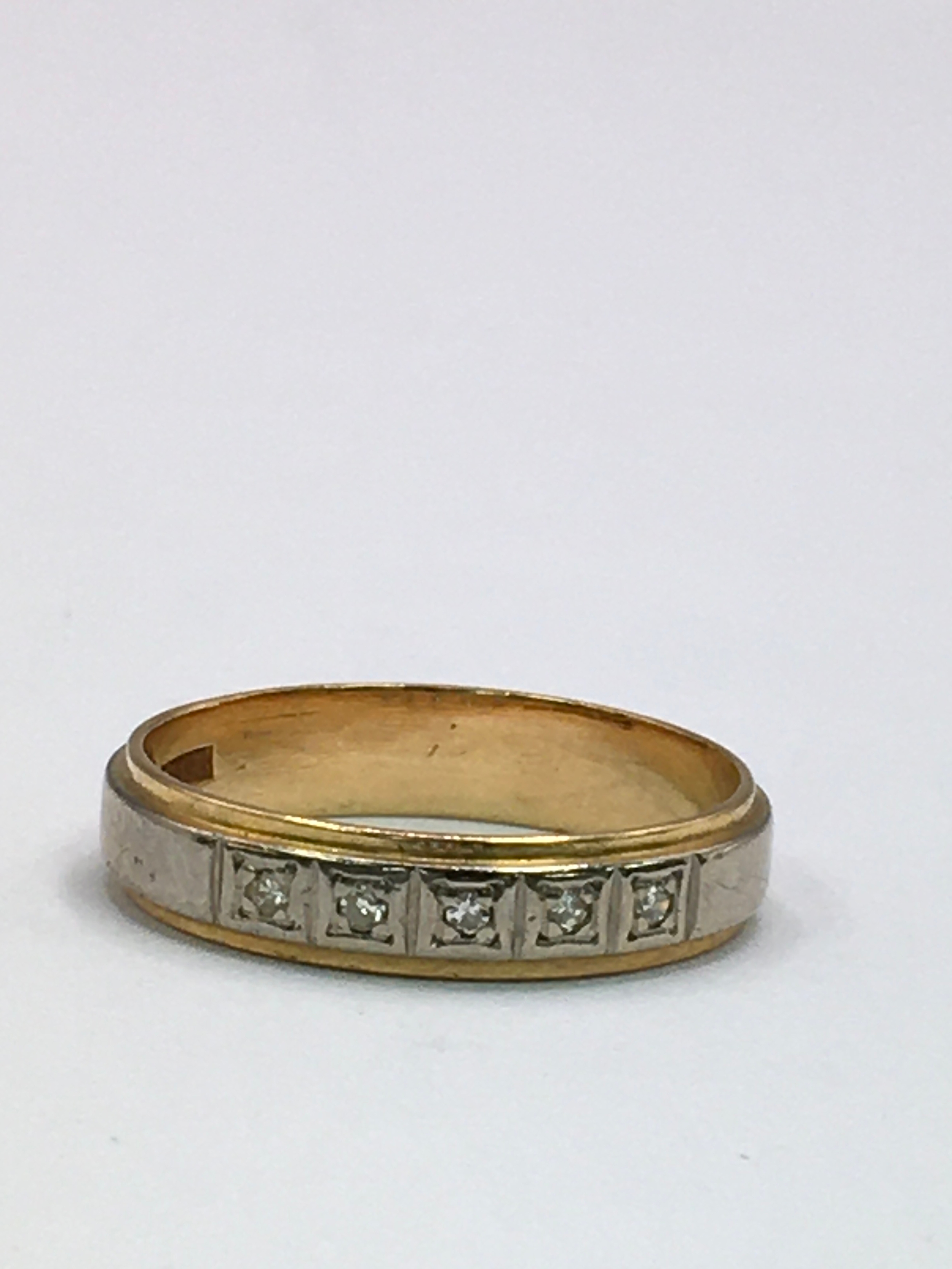 An 18ct gold, two tone wedding band ring set with small white stones. Size O