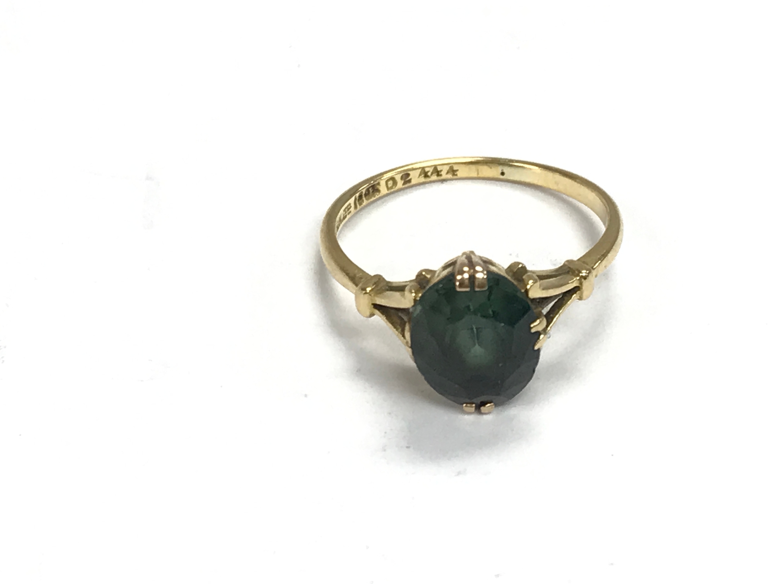 An 18ct gold ring set with green stone. Size O and 3g 