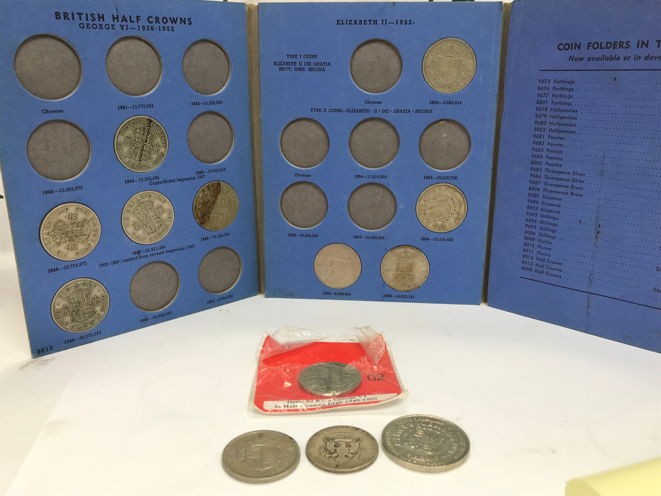 A small collection of coins including Half Crowns, Half Dollar, Las Vegas circus hotel casino token