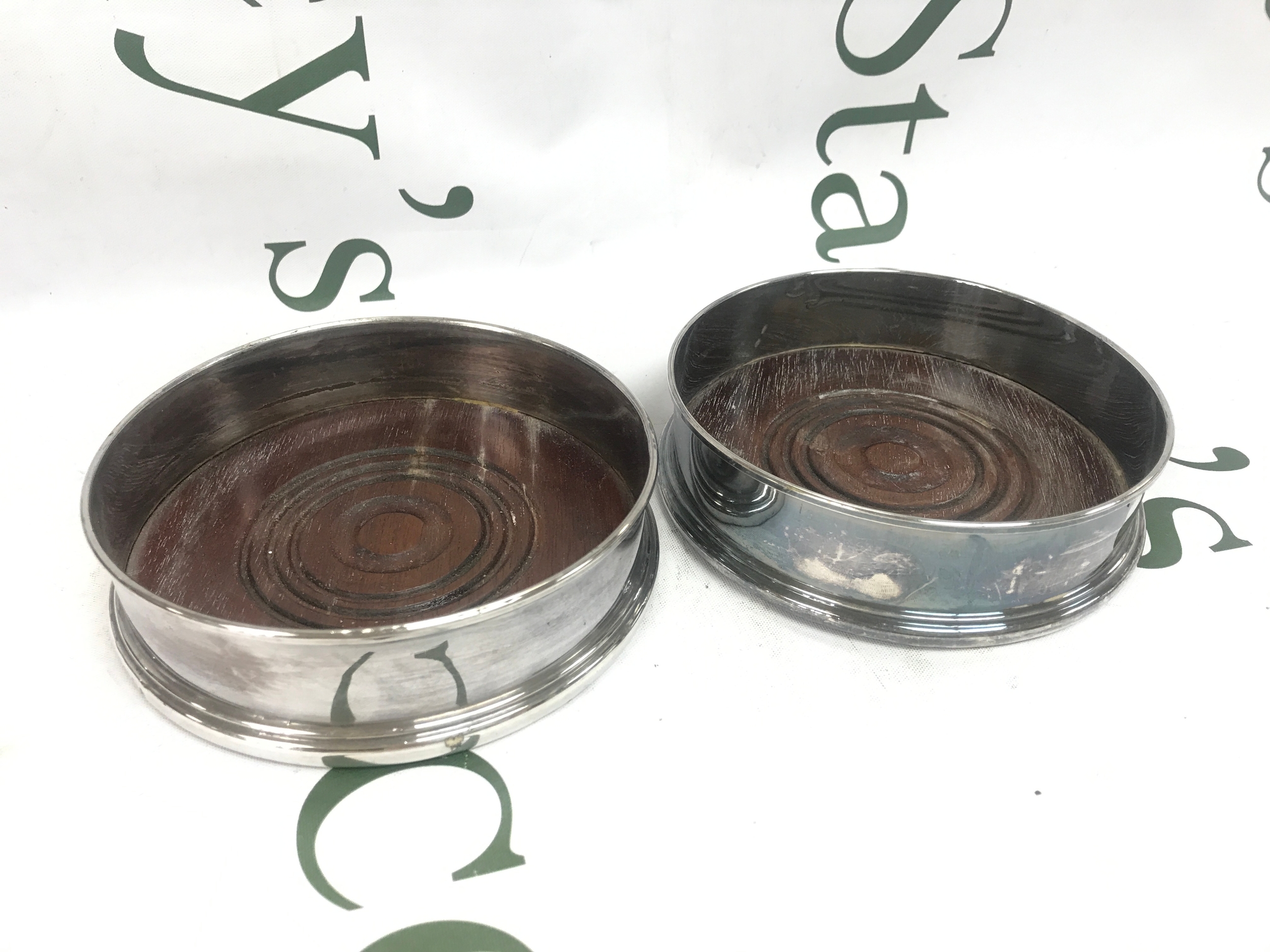 a pair of silver wine coasters , 13cm wide 