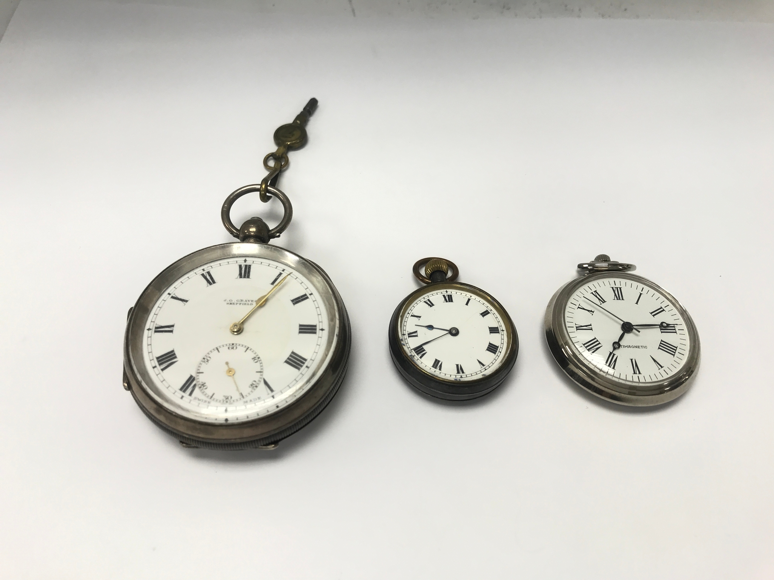 Three pocket watches including silver example.