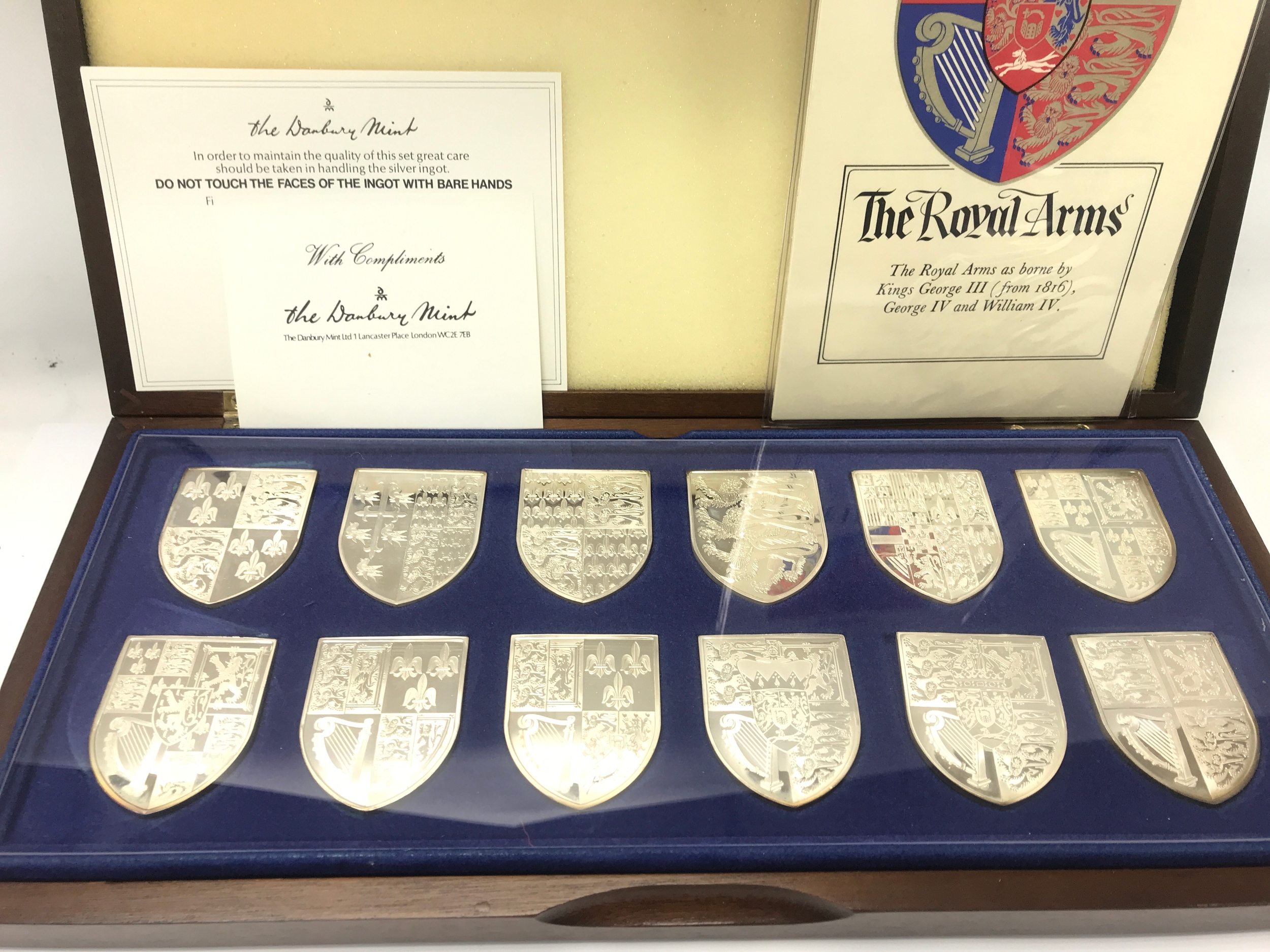 The Royal Arms Collection, a cased set of twelve shield-shaped silver medallions or ingots produced by the Danbury Mint. Total weight approximately 580g