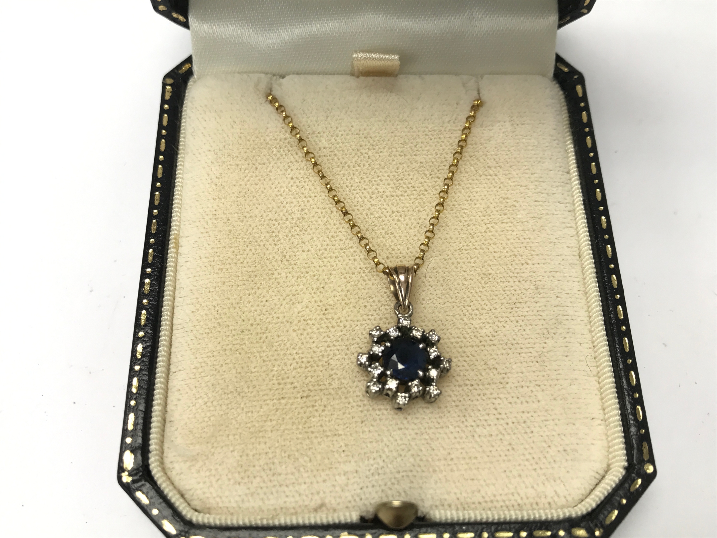 A 9ct chain with a silver sapphire and white stone pendant