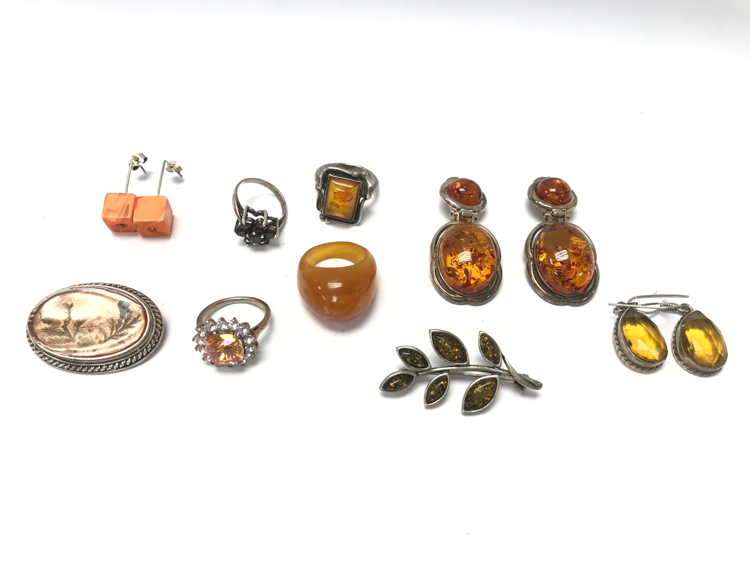collection of vintage or antique jewellery pieces featuring silver and amber or similar gemstones and materials.