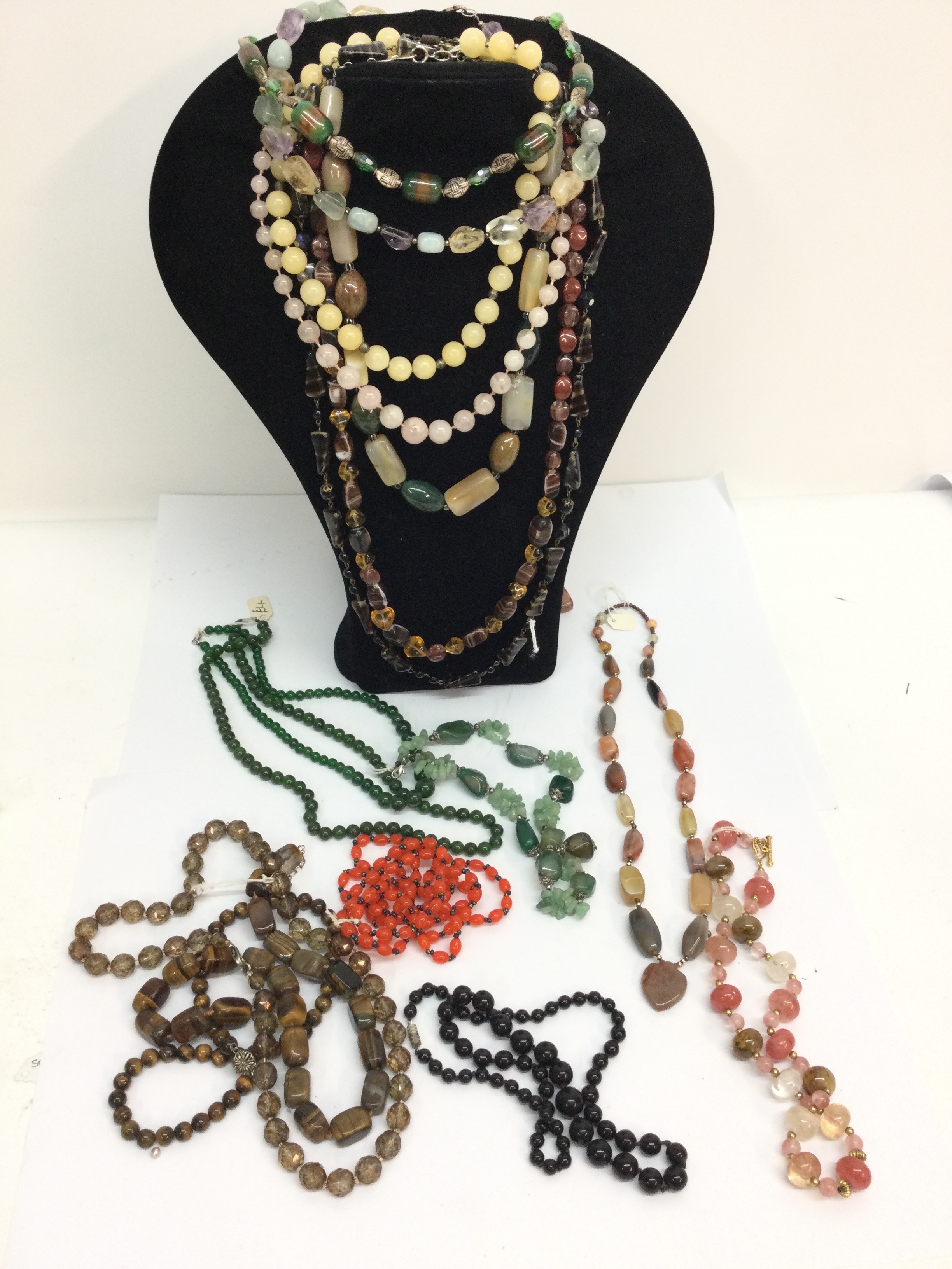 A collection of polished hardstone bead necklaces including Tiger's Eye.