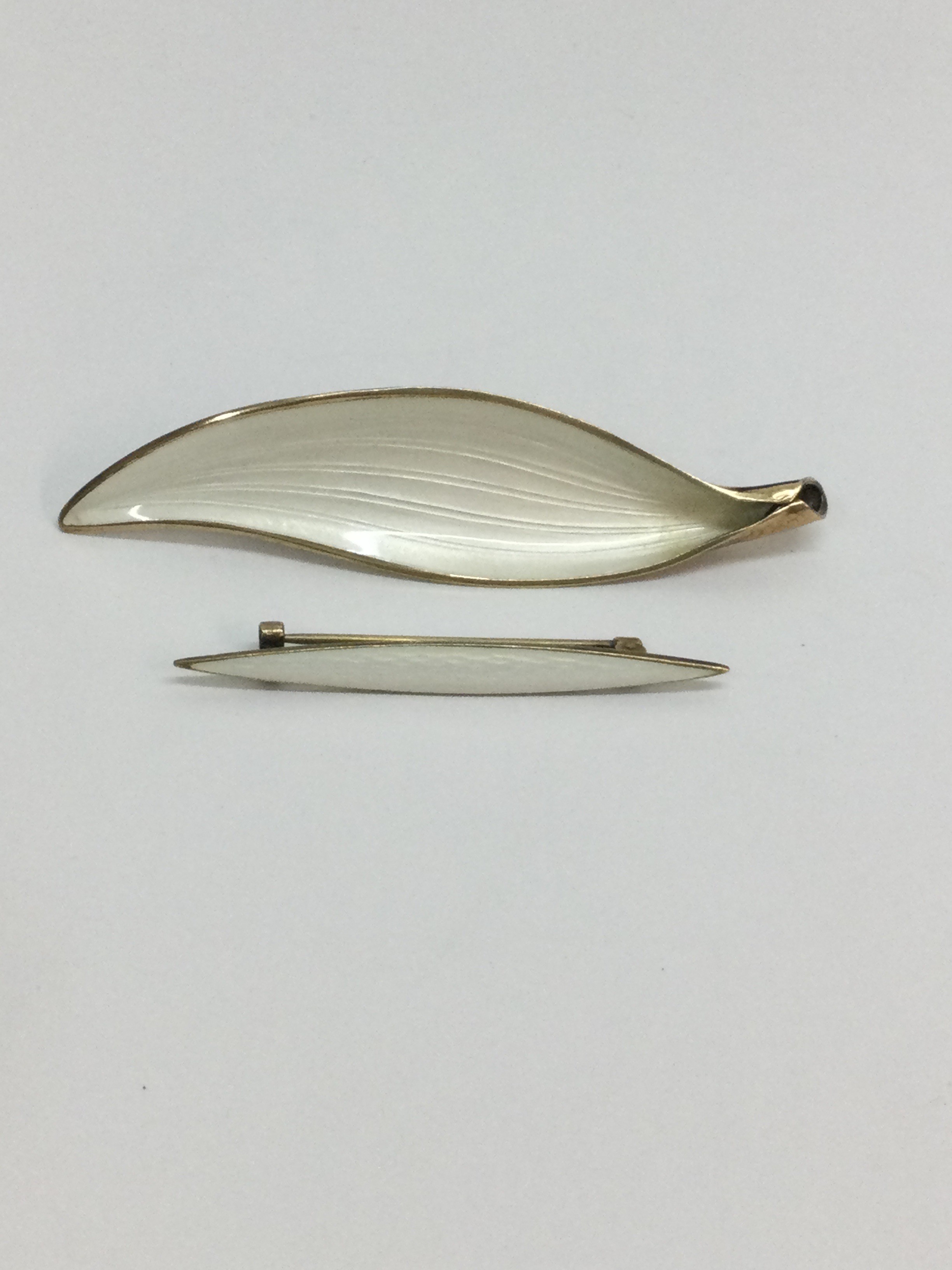 A Norwegian, Arne Nordlie silver gilt and enamel leaf brooch of modernist design, plus another example of similar style, stamped 925 with maker's mark. Approx 8.5 and 5.5cm respectively. 