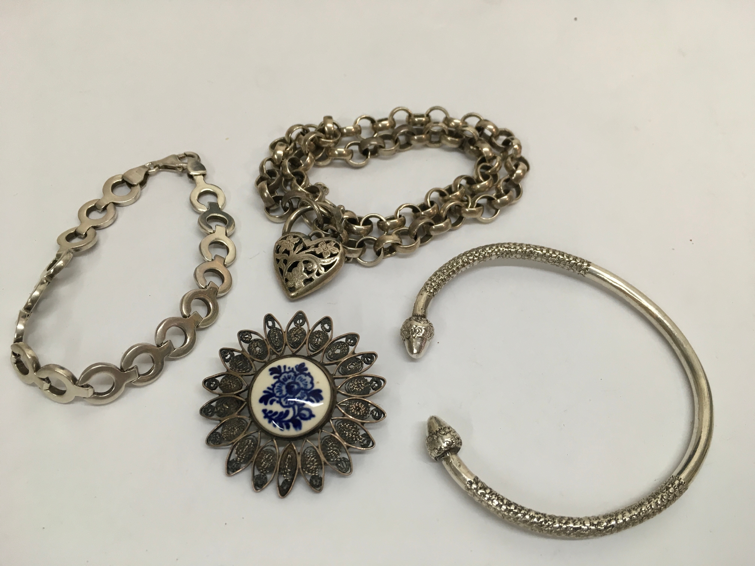 A 925 silver link bracelet, an untested white metal chain example with padlock clasp, a cuff bangle and filigree brooch.