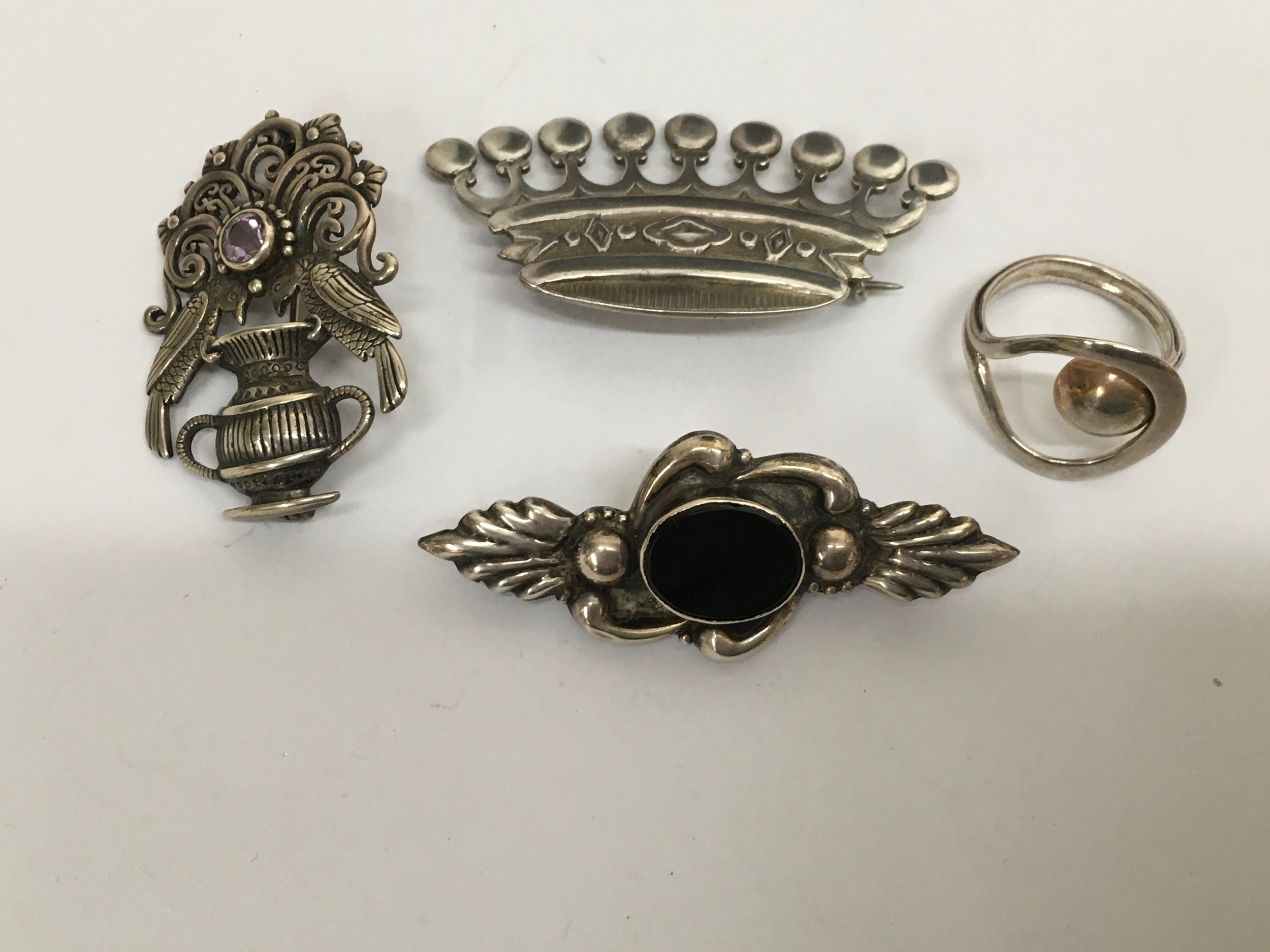 Two 925 silver brooches, a continental white metal example in the form of a crown and a ring.