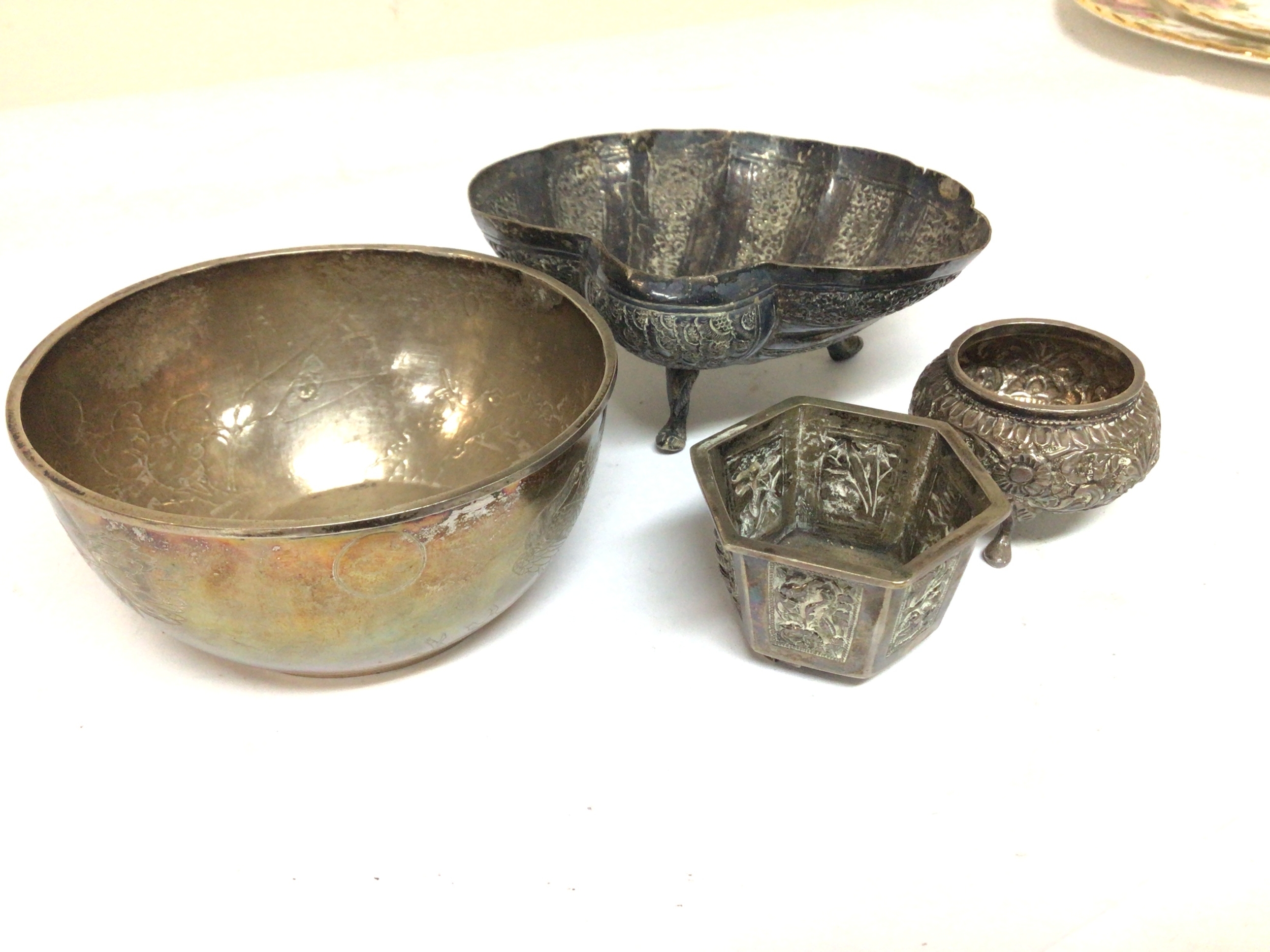  A Chinese silver bowl engraved decoration with birds and flowers. 9cm wide with caricature marks to the base and other small white metal dishes including a Wang Hing small octagonal dish. 