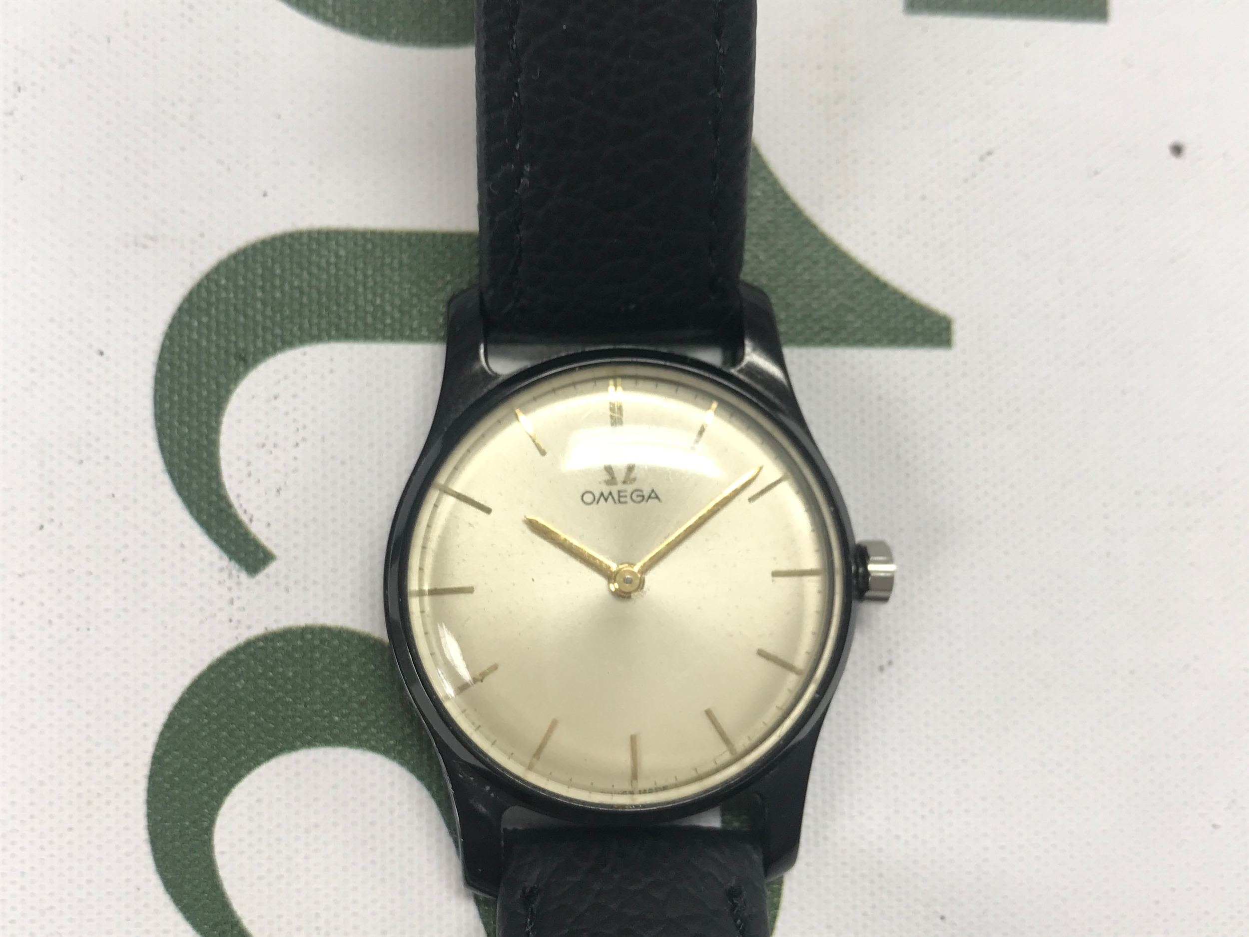 An omega movement and dial in an aftermarket black case. ideal for parts / repair.