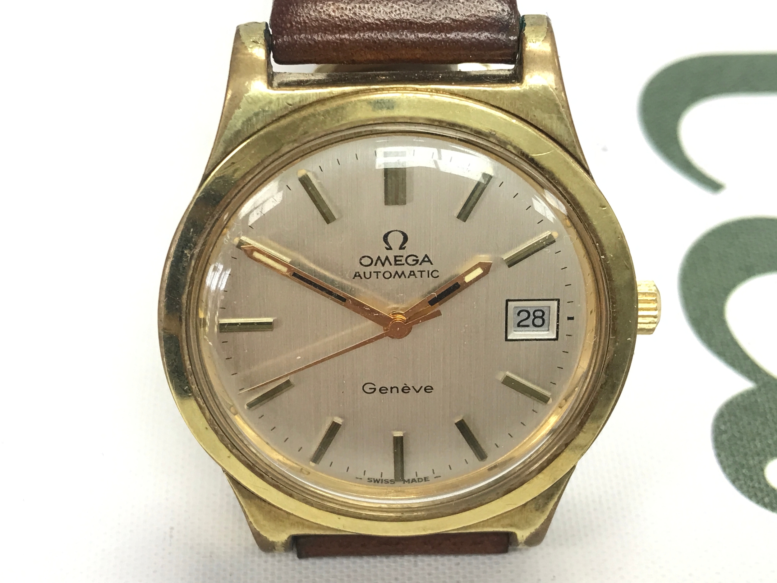 vintage gold-plated Omega Genève Automatic men's wristwatch with a date window and a brown leather strap