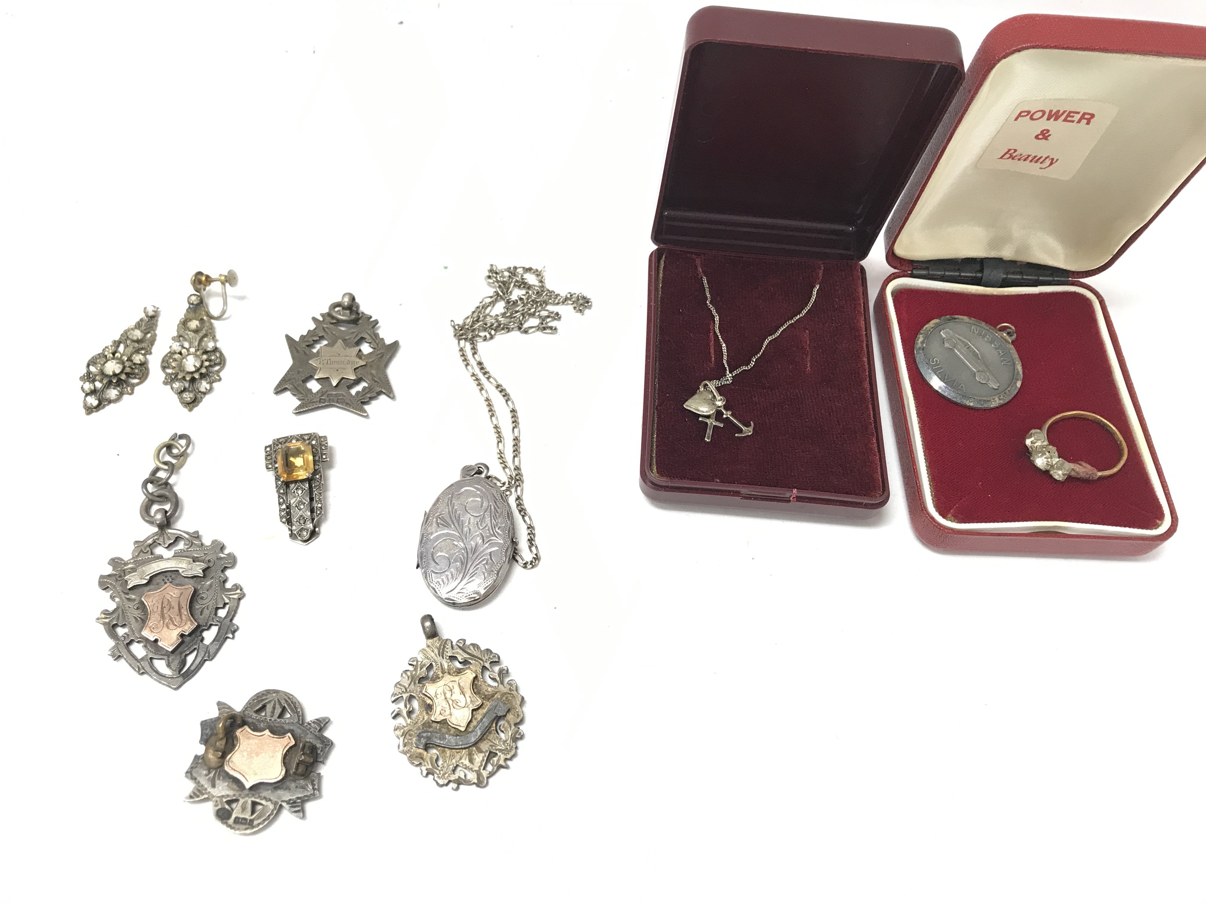 A collection of predominantly silver items including medals and chain.