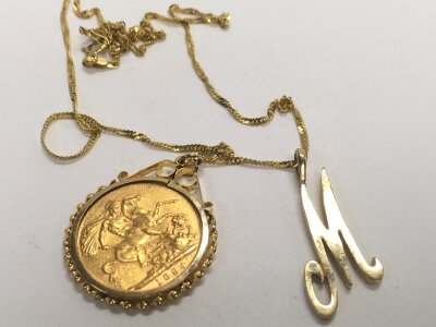 An 1894 full sovereign in a pendant mount on a 9ct gold double curb twist chain and an M letter pendant. Approx weight 12.31 grams.