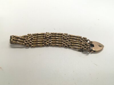 A 9ct gold heavy gate bracelet with a heart padlock clasp. Approx weight 16 grams.