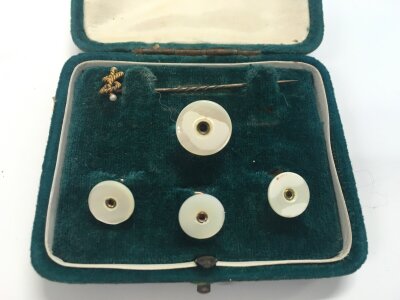 A 15ct stamped pin stick and mother of pearl buttons.