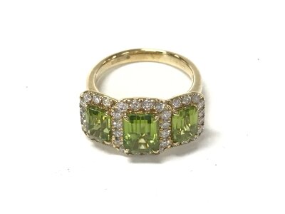 9ct yellow gold trilogy ring set with three step cut peridot each surrounded by diamonds. Size O