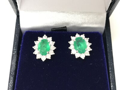 A pair of 9ct white gold emerald and diamond cluster studs. Emeralds approx 1.50 ct and 0.72 diamonds.