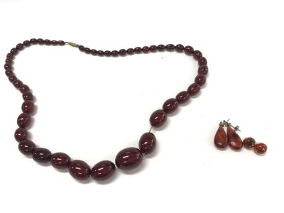 Two pairs of amber earrings and a bead necklace.