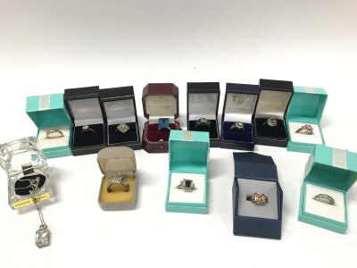 A collection of silver and other rings including a silver necklace.