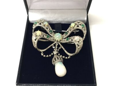 A large silver art nouveau style fancy bow bar brooch set with cabochon Opal and diamond drop.