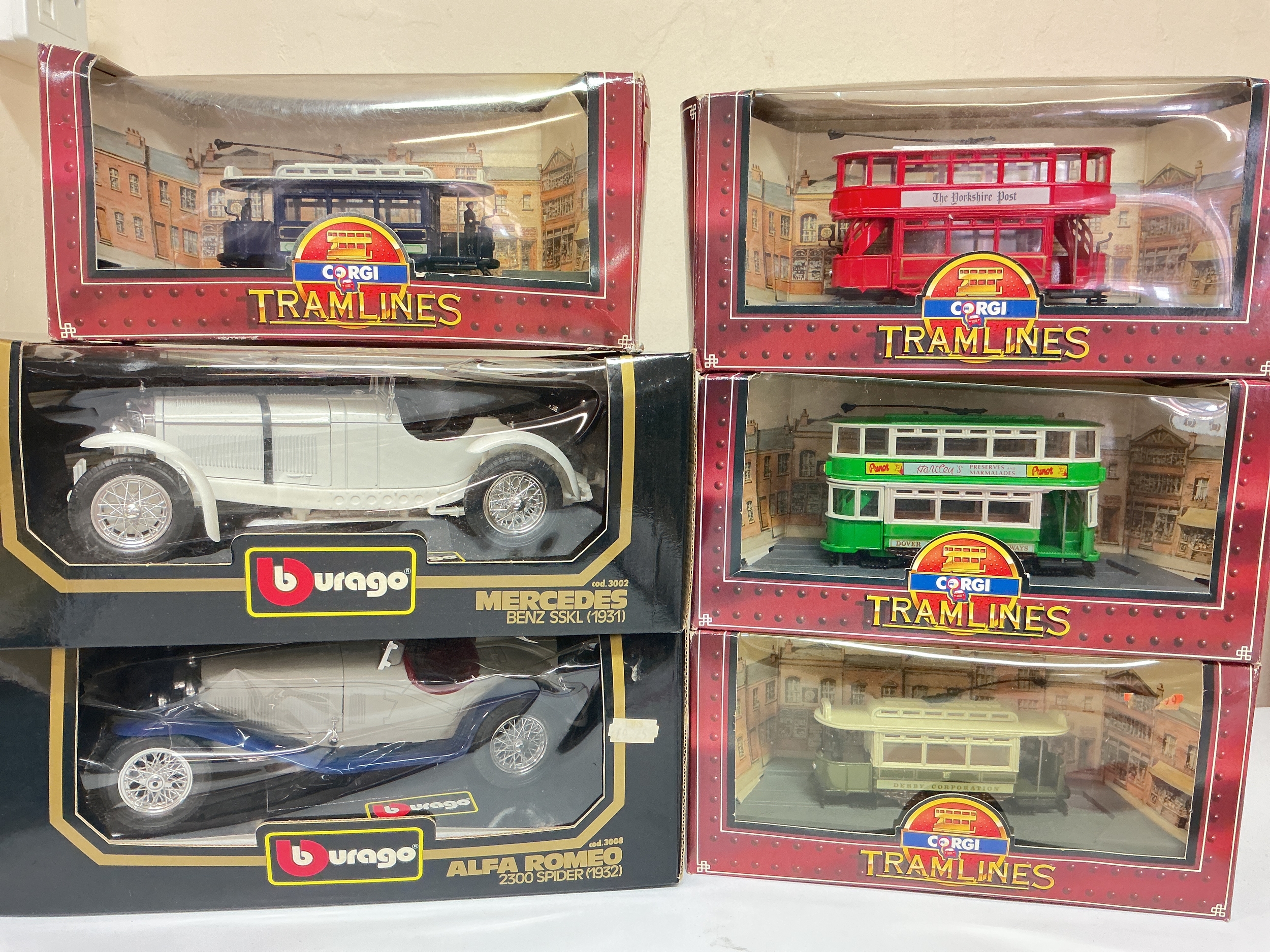 2 Boxed Burago Diecast A Mercedes Benz SSKL 1931, A Alfa Romeo 2300 Spider Both 1/18 Scale And 4 Corgi Tramlines.