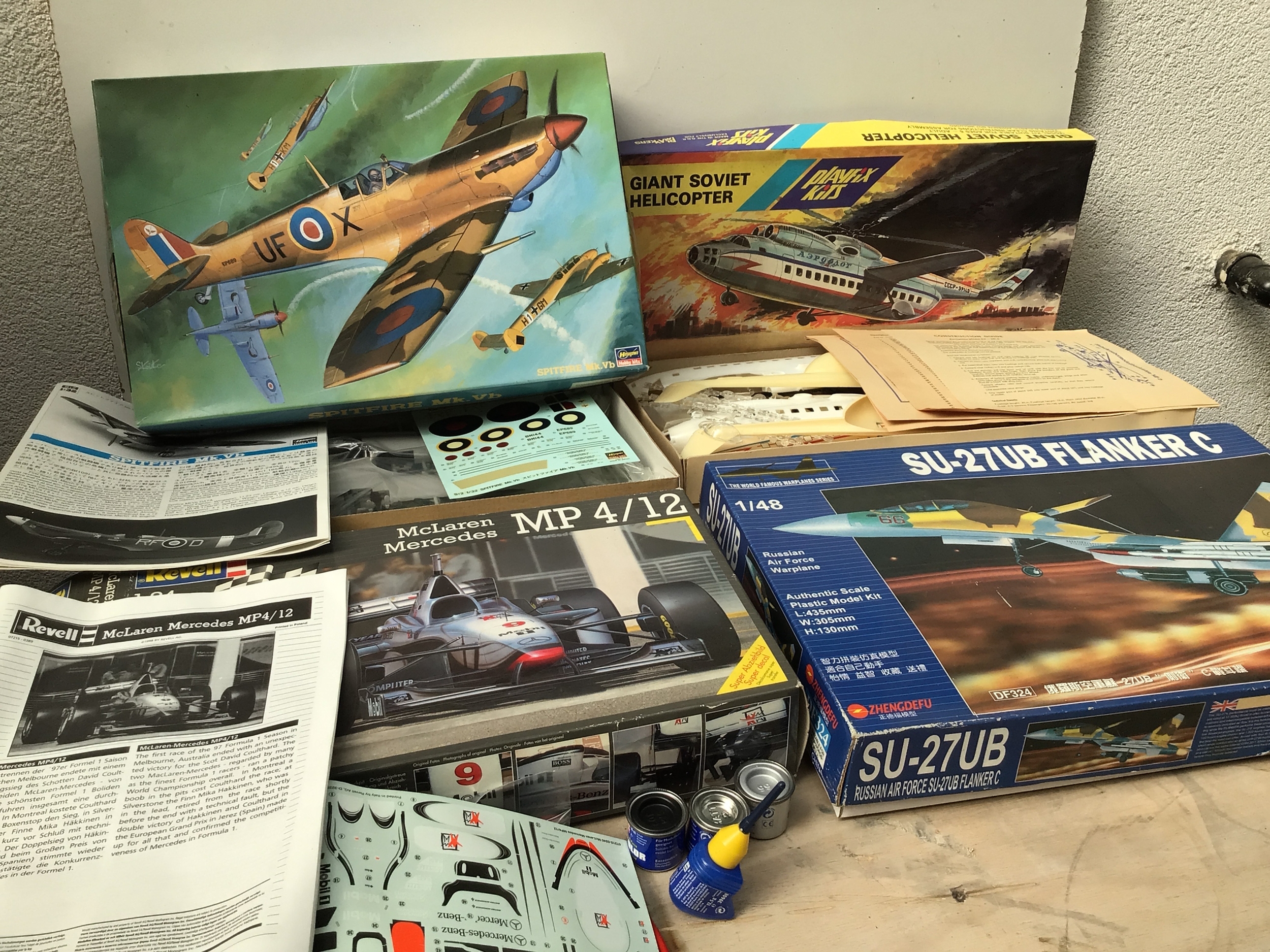 A bag containing boxed model kits by various manufacturers including Revell, Zhengdefu, Hasegawa etc.  Featuring aircraft and cars in a variety of scales.  No reserve.