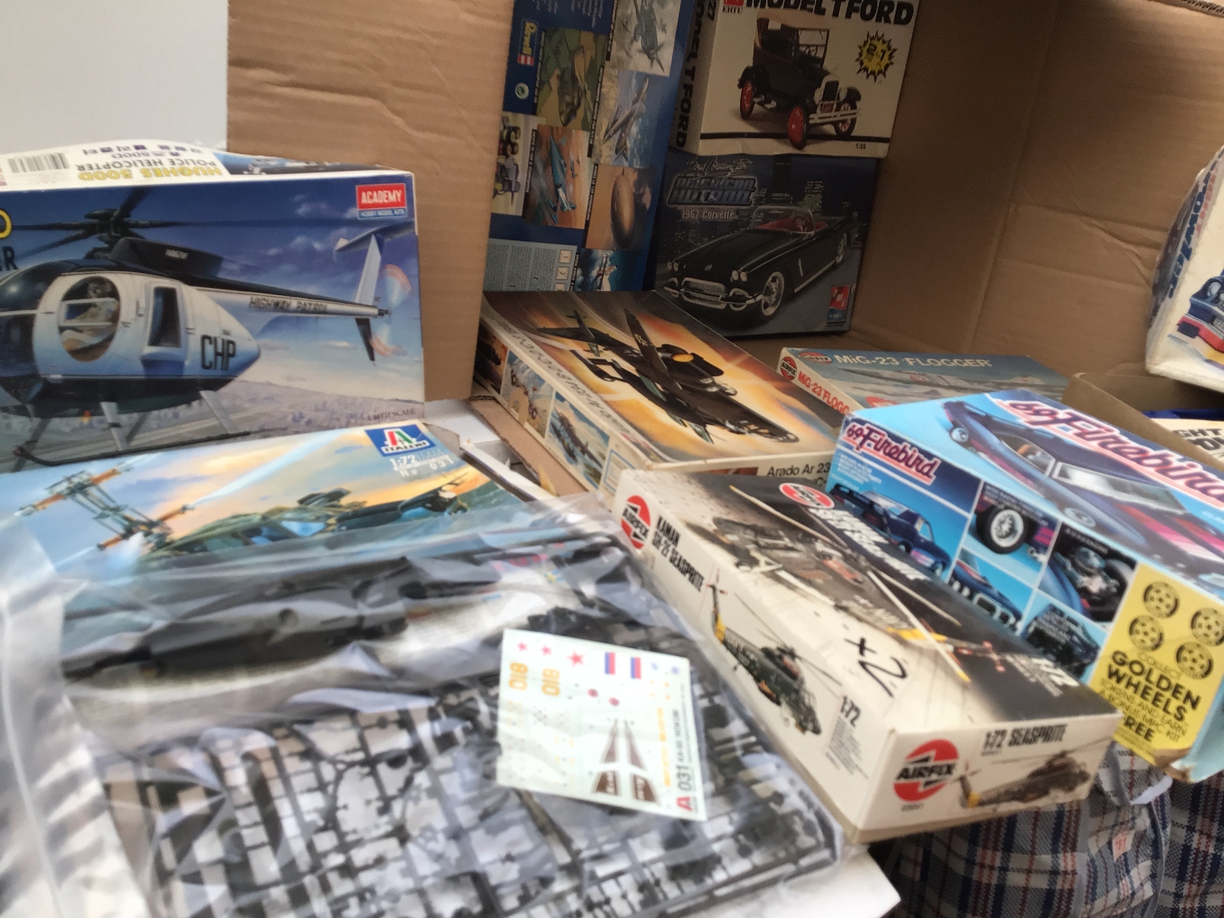 A box containing a collection of boxed model kits featuring aircraft and cars.  Manufacturers include Airfix, Academy, Italeri etc.  various scales, no reserve.