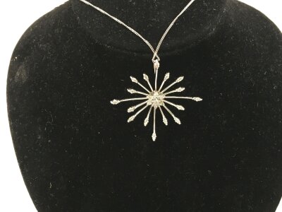 A 9ct white gold modern design necklace with star pendant stone set.
4.03g and approximately 36mm wide.