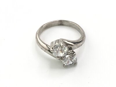 A white metal ring set with two large CZ stones. Size P