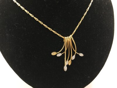 An unusual 18ct gold necklace with shaped drops each set with a diamond 
11.07g