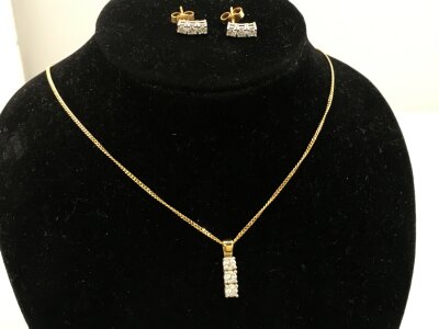 An 18ct gold necklace with diamond pendant and matching earrings.
5.66g
