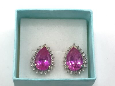A pair of gold earrings set with vivid pink stones possible tourmaline