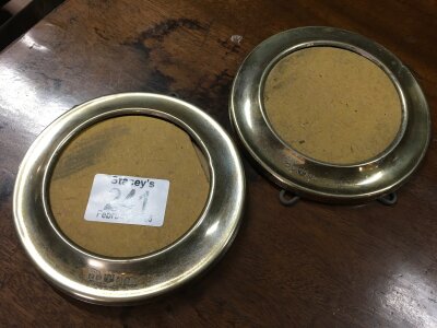 A pair of small circular silver plated photo frames